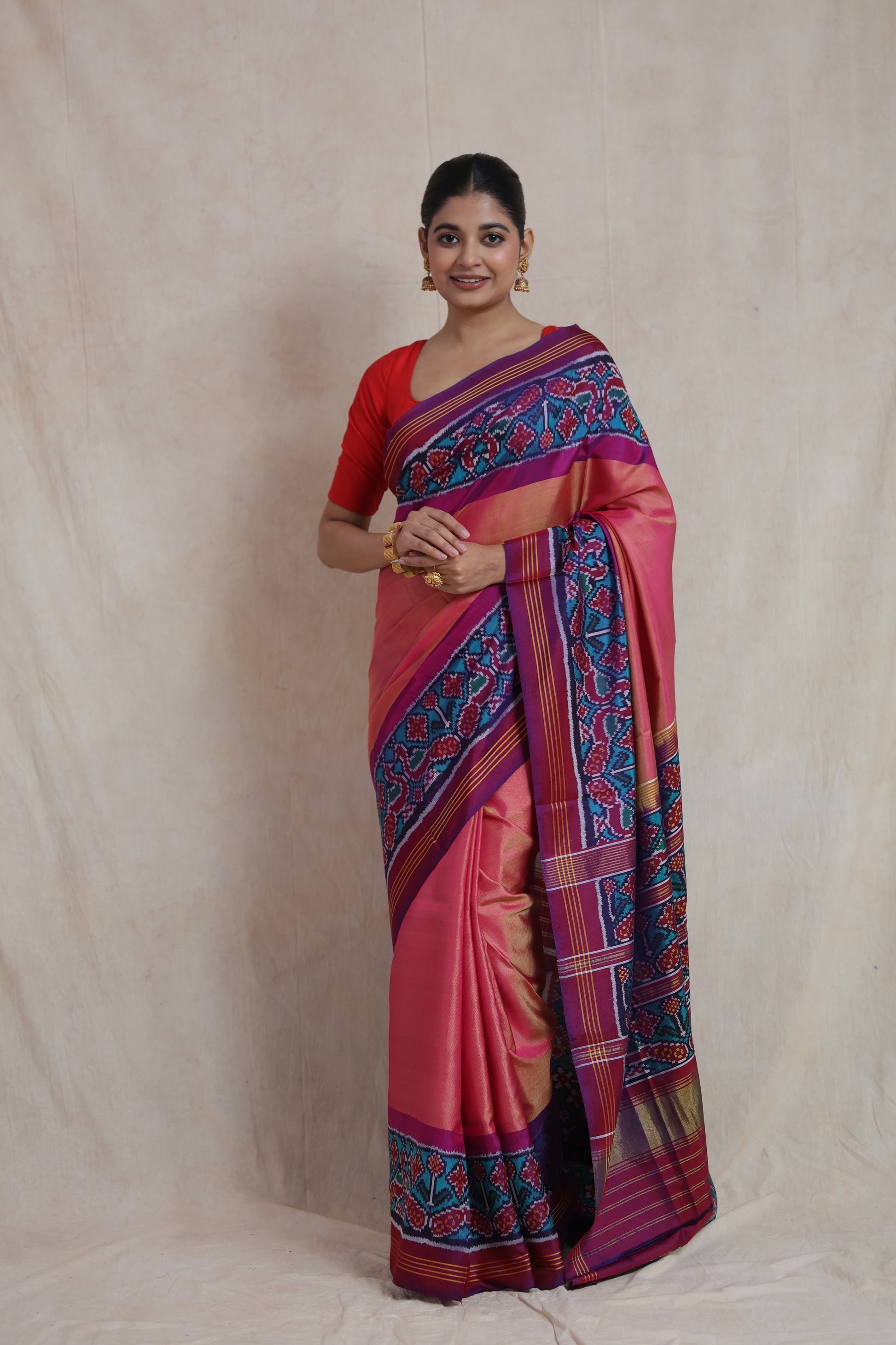 Full-length view of blush pink Patola handloom silk saree with vibrant ikat border and pallu