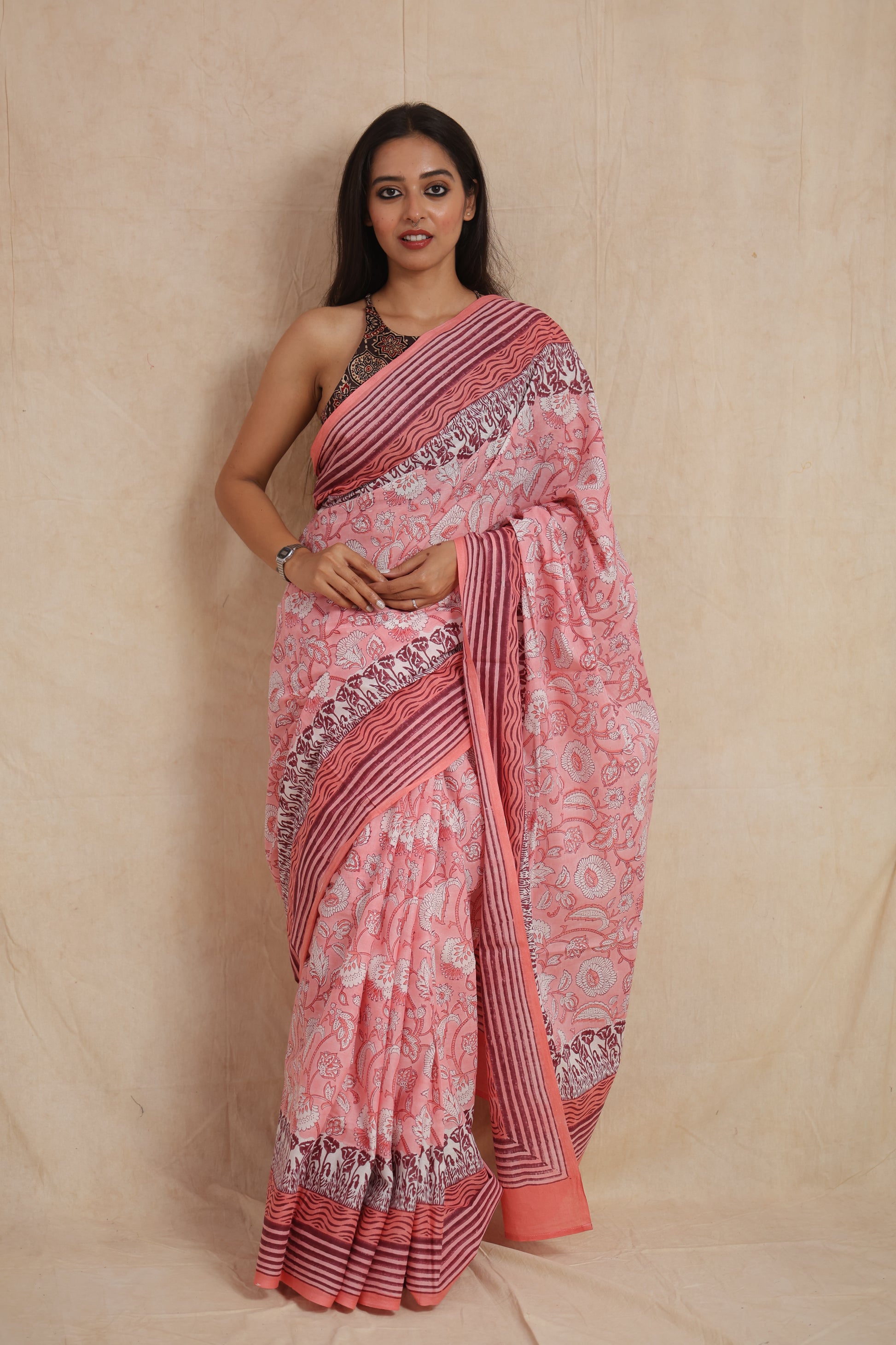Model wearing blush pink Sanghnaree cotton saree with floral print and striped border front view