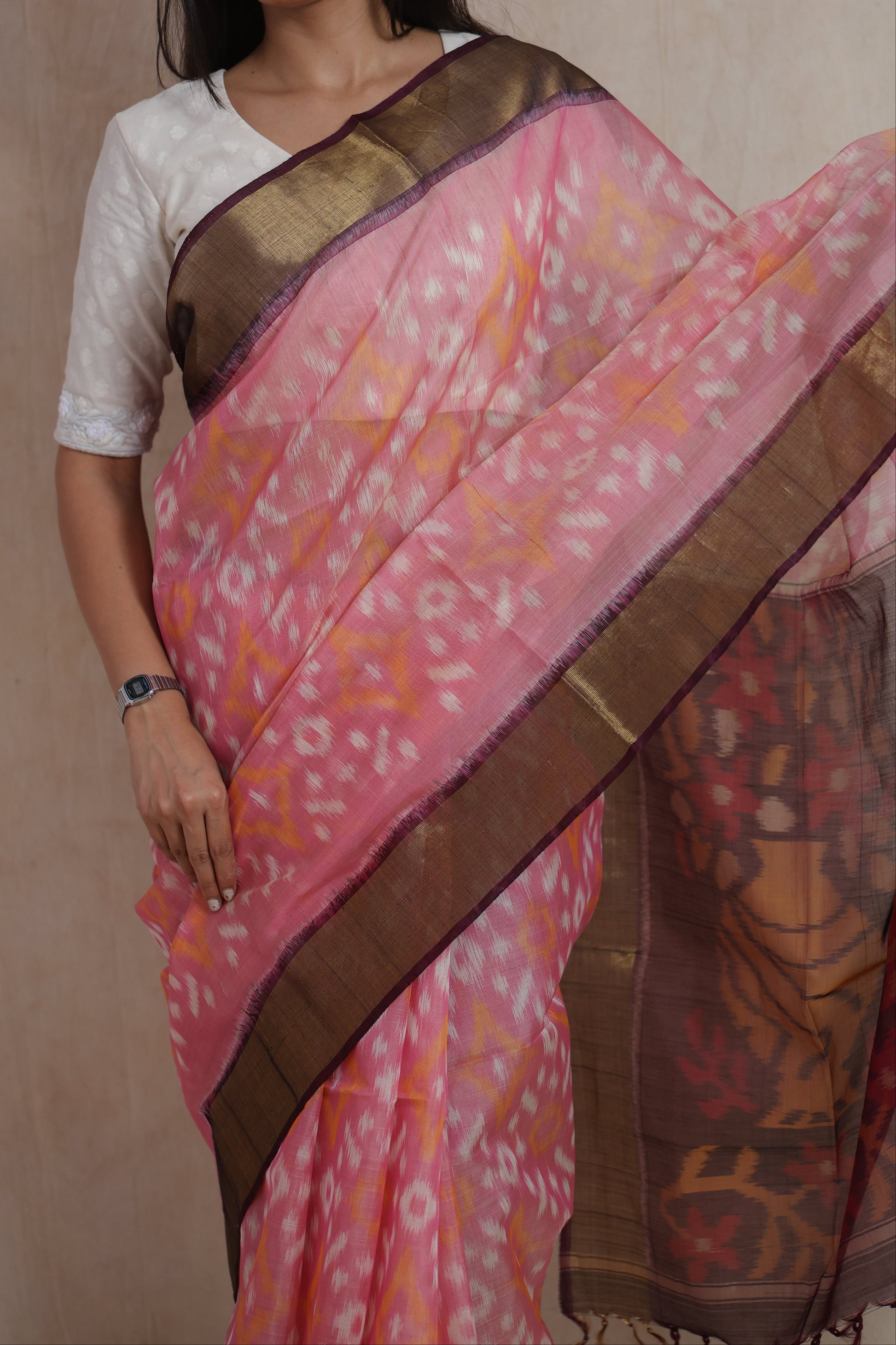 Close-up of blush pink Panchampali silk cotton saree highlighting Ikat motifs and woven border details