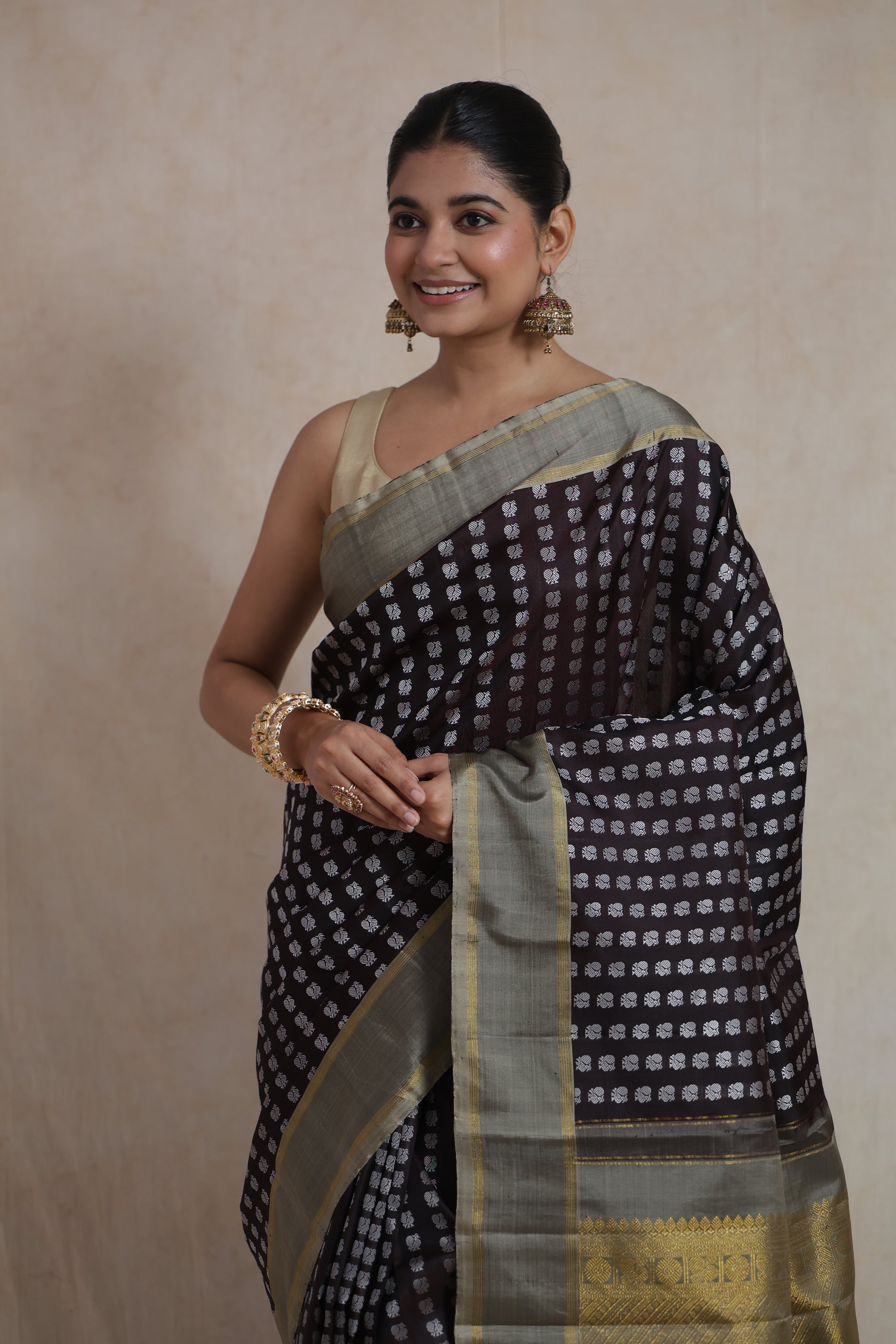 Close-up of silver butta detailing on deep brown Kanjivaram silk saree