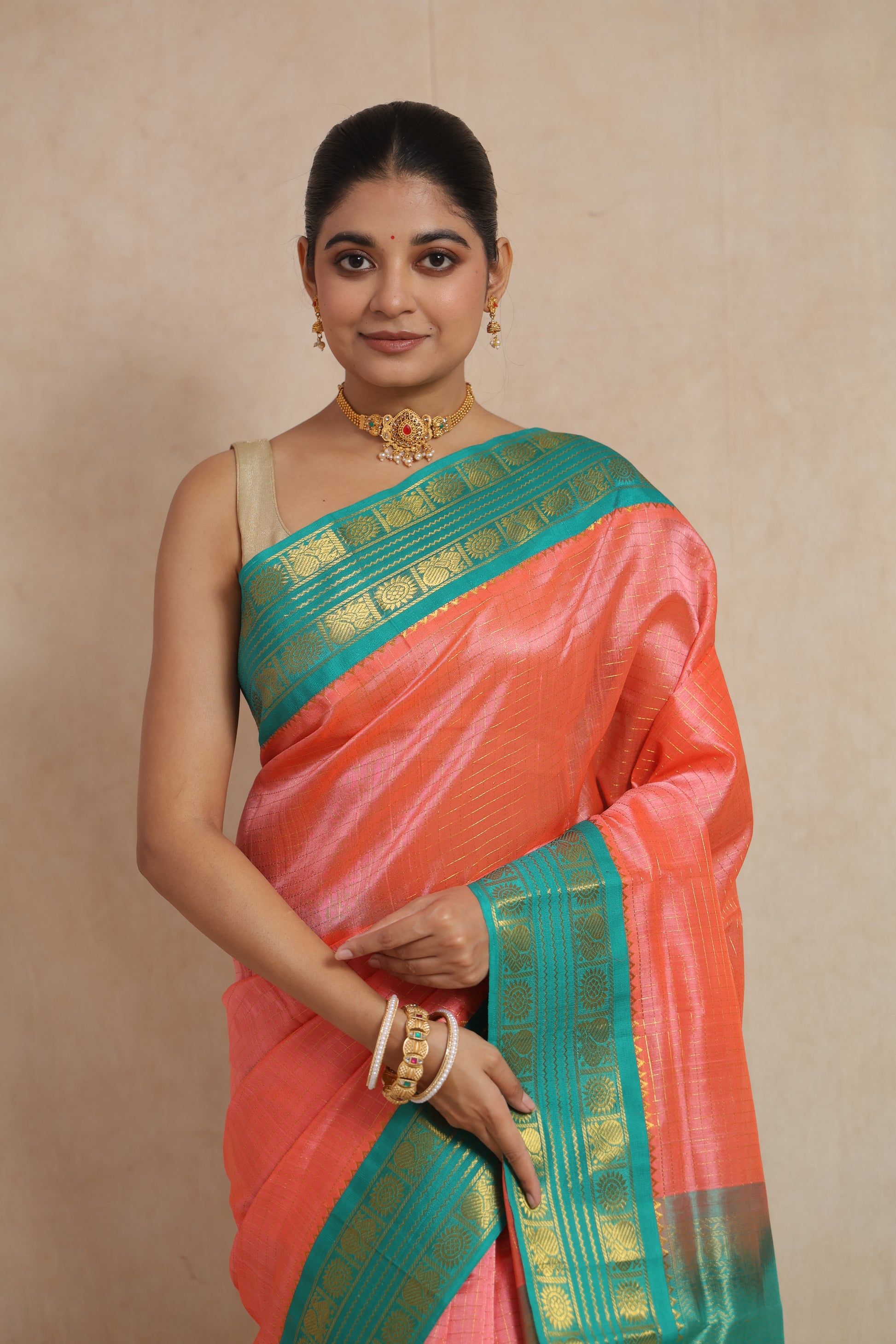 Portrait view of coral peach Kanchipuram Sico saree with woven motifs