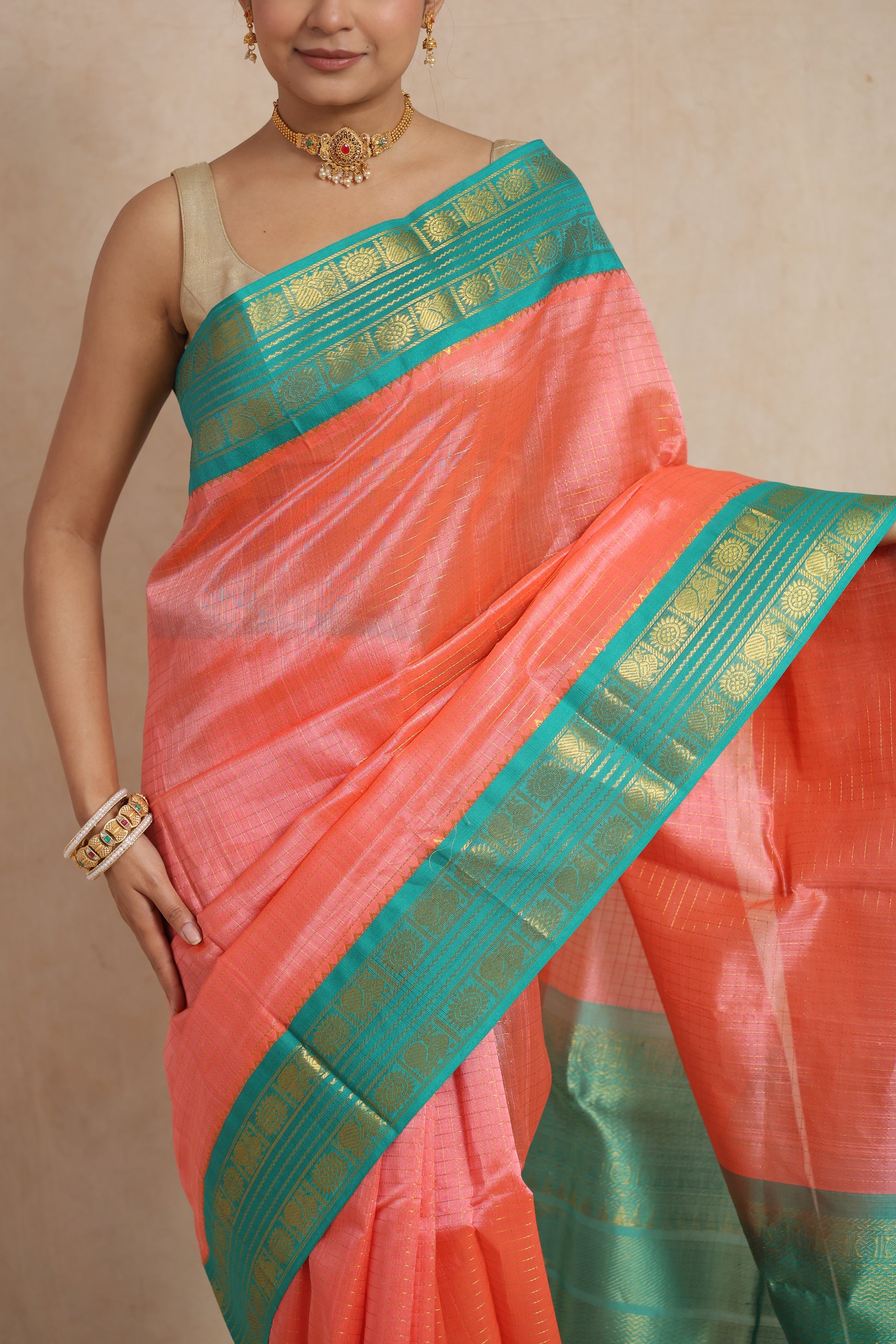 Close-up of coral peach Kanchipuram Sico saree with aqua green border