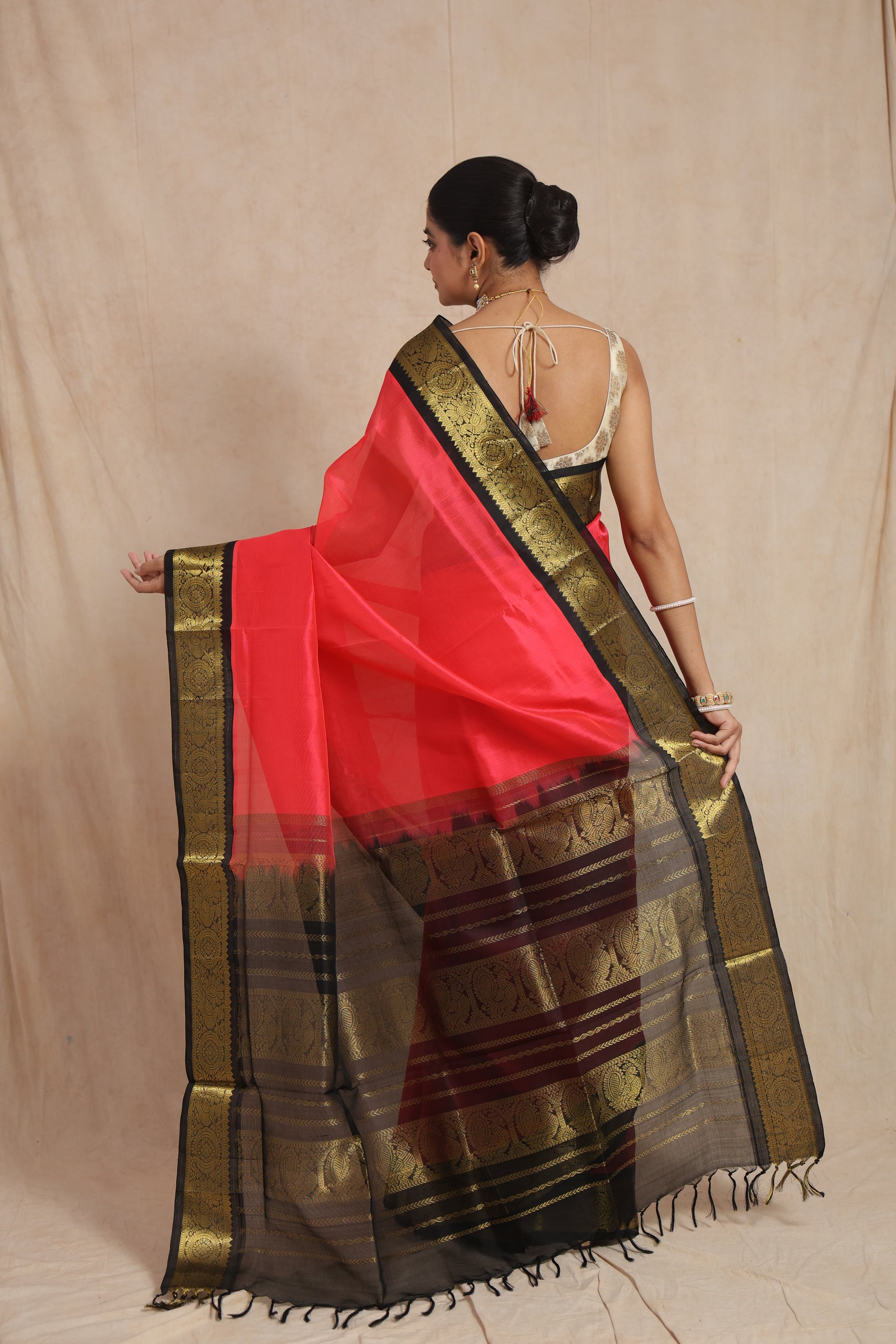 Back view of coral pink Kanchipuram Sico saree with rich woven pallu and tassels