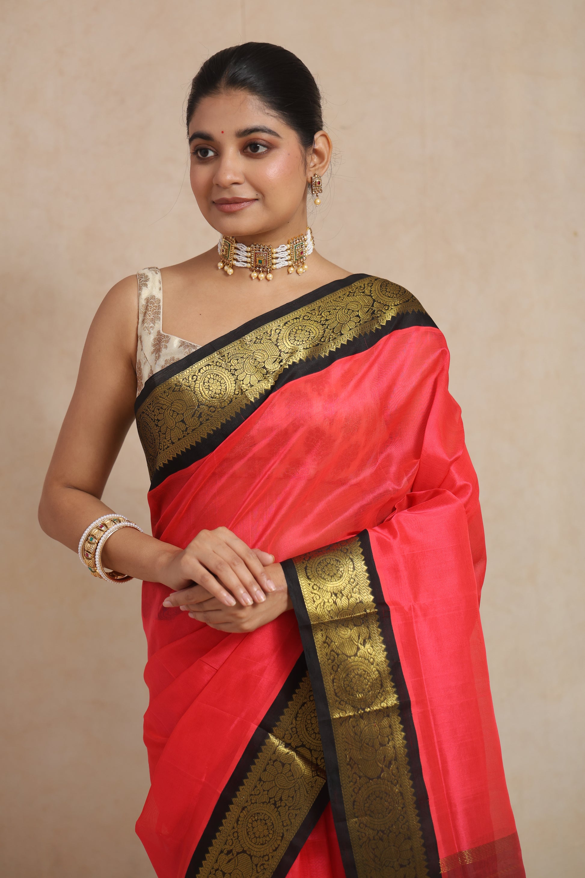 Close-up of coral pink Kanchipuram Sico saree with antique gold floral woven border
