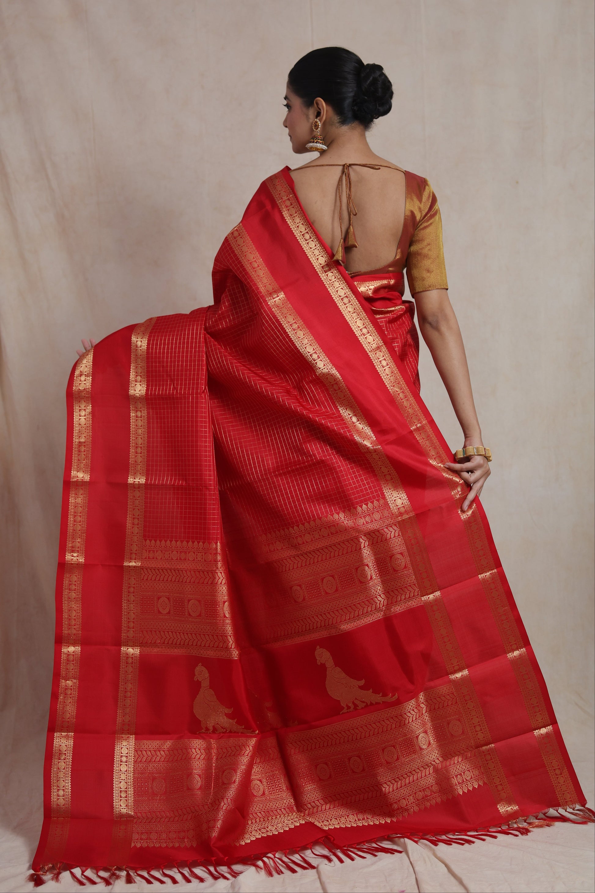 Back view of crimson red Kanjivaram pure silk saree featuring peacock motifs and richly woven traditional pallu