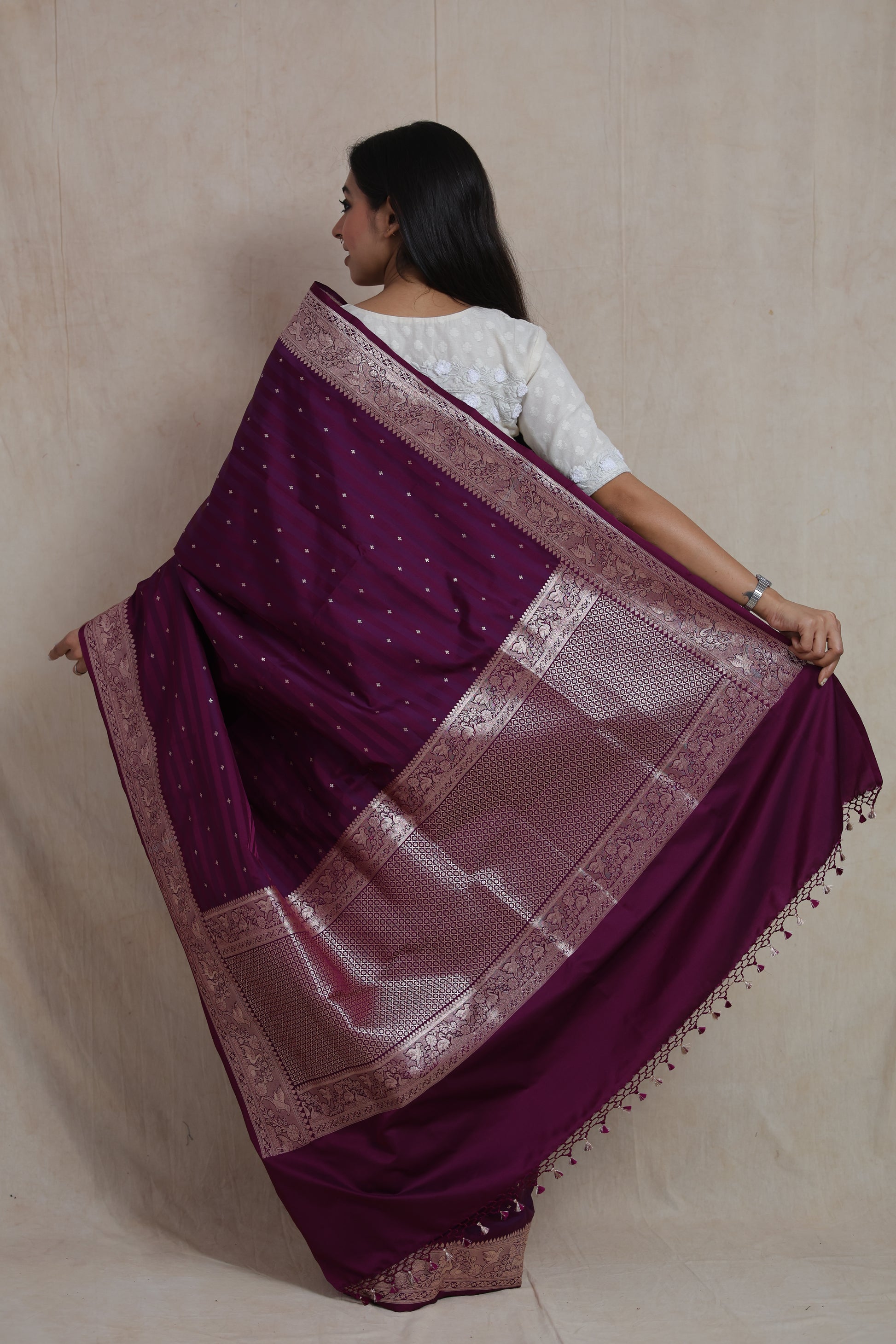 Back pallu view of deep wine Banarasi silk saree with rich zari weaving and tassels.