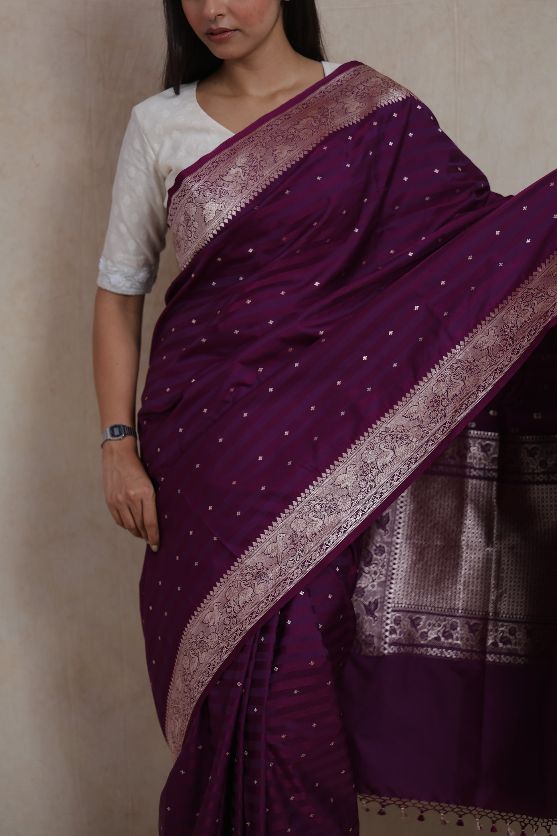 Detailed drape view of deep wine silk saree with delicate zari buttas and border motifs.