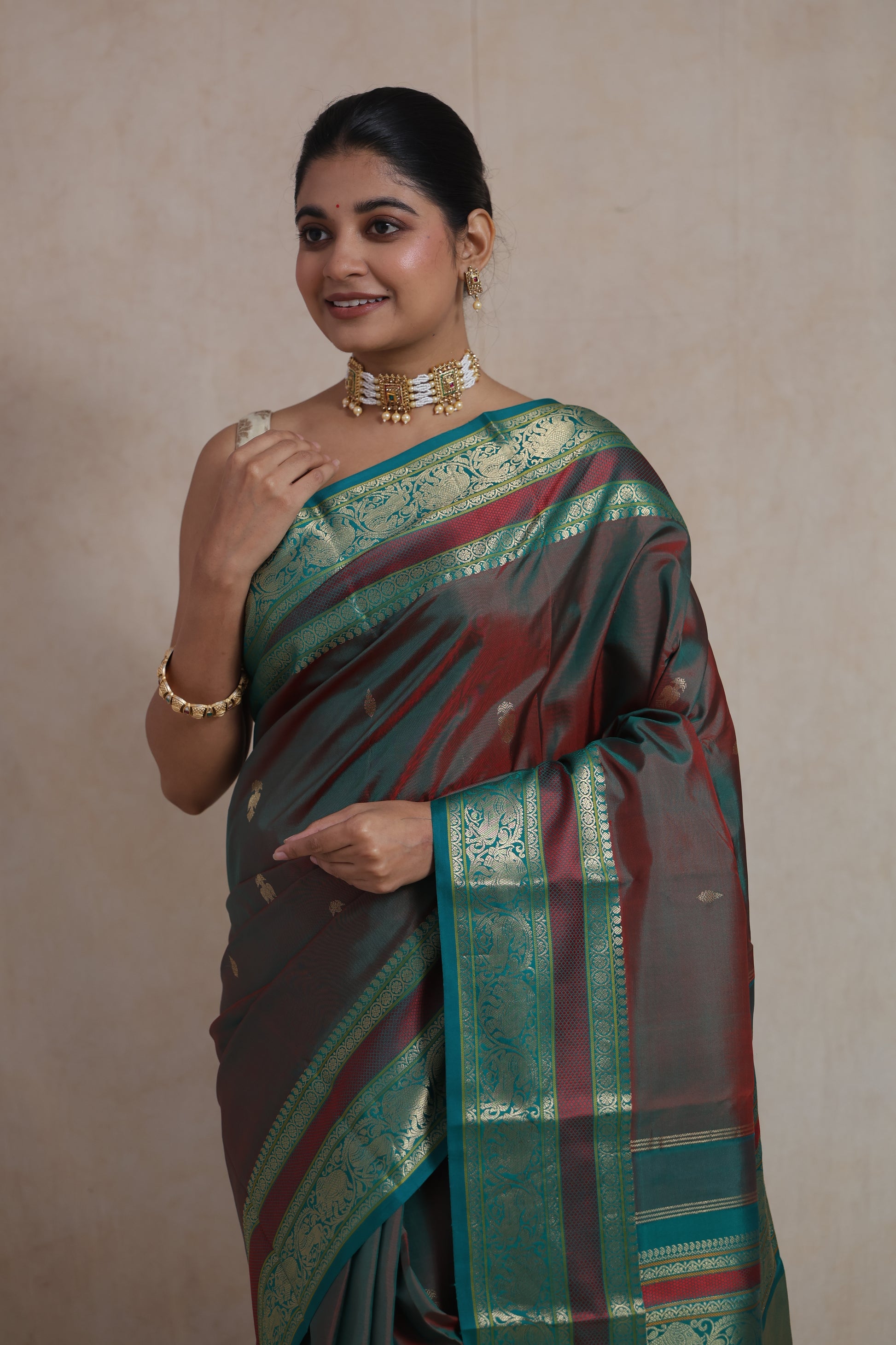 Back view of dual-tone maroon and teal Kanchiwaram silk saree with traditional zari weaving
