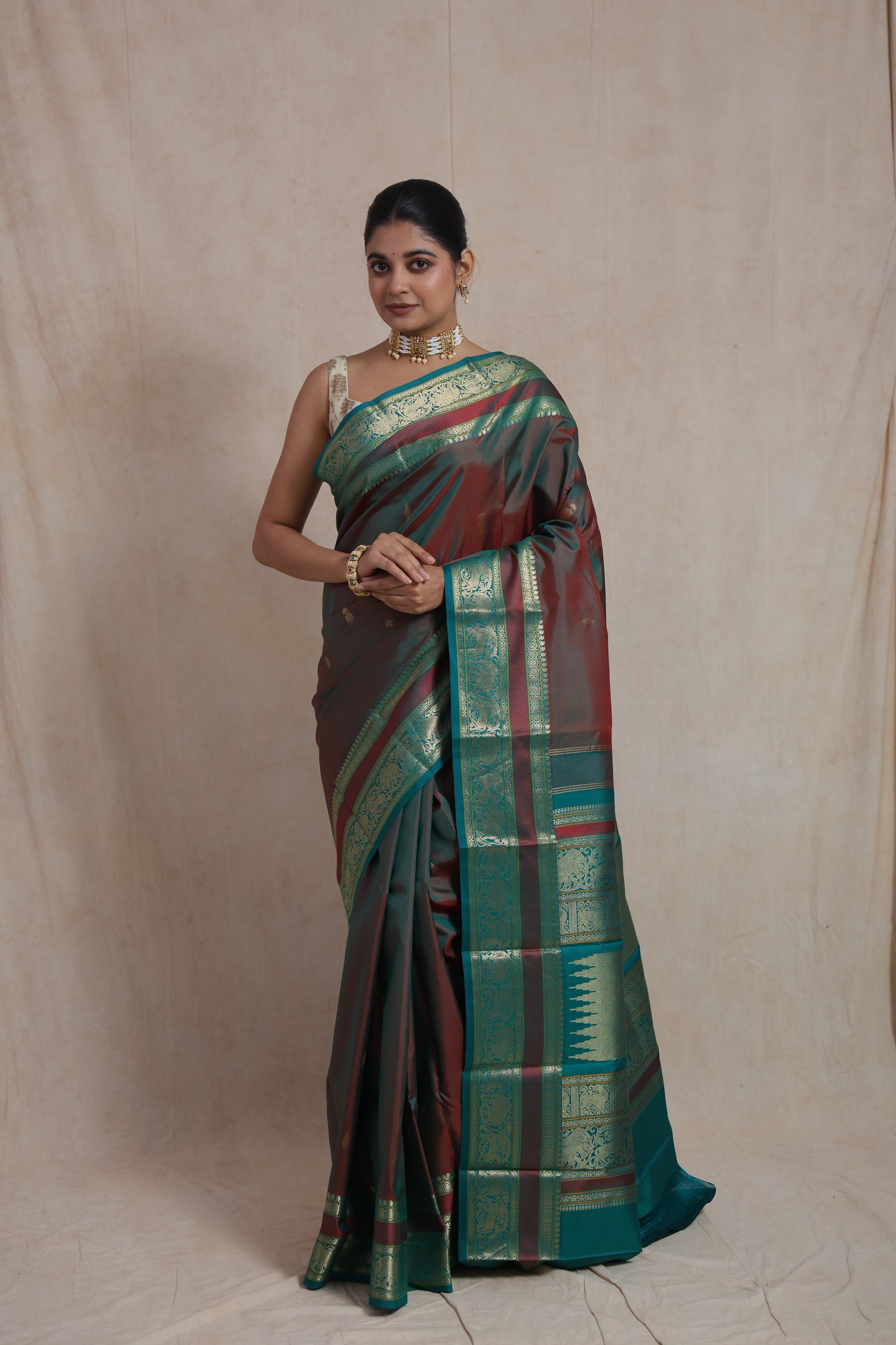 Elegant drape of dual-tone maroon and teal silk saree with rich woven pallu