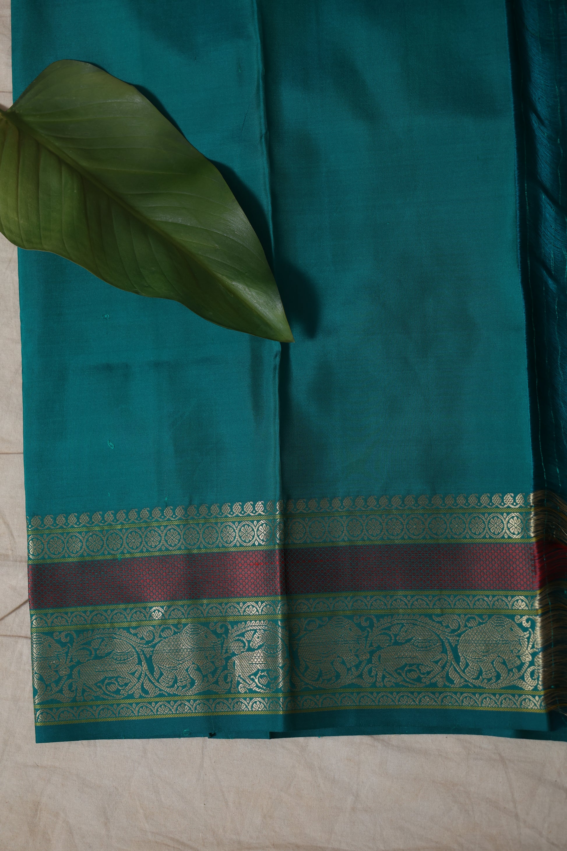 Model wearing dual-tone maroon and teal Kanchiwaram silk saree with zari woven pallu