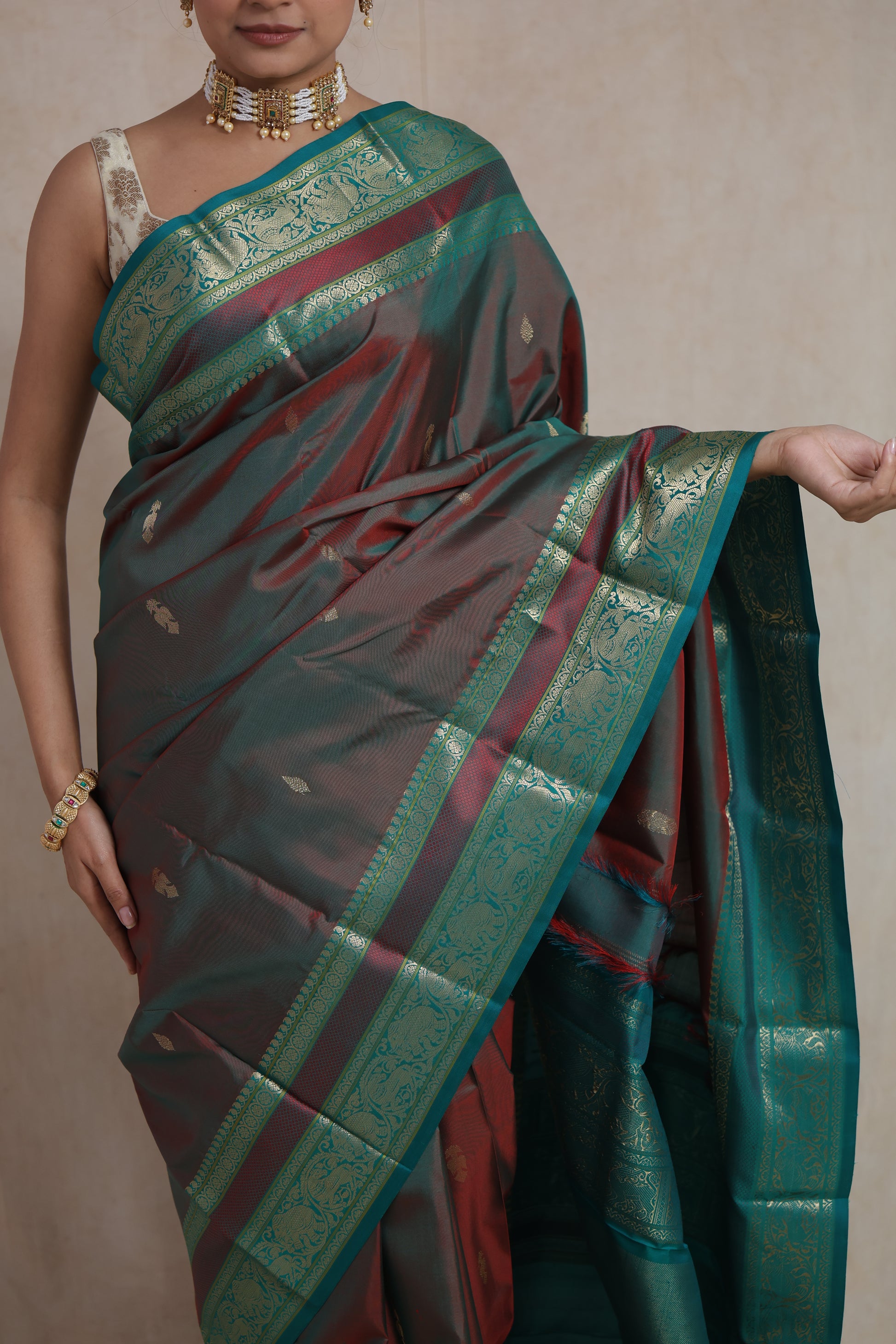Elegant standing pose in dual-tone maroon teal Kanchiwaram silk saree