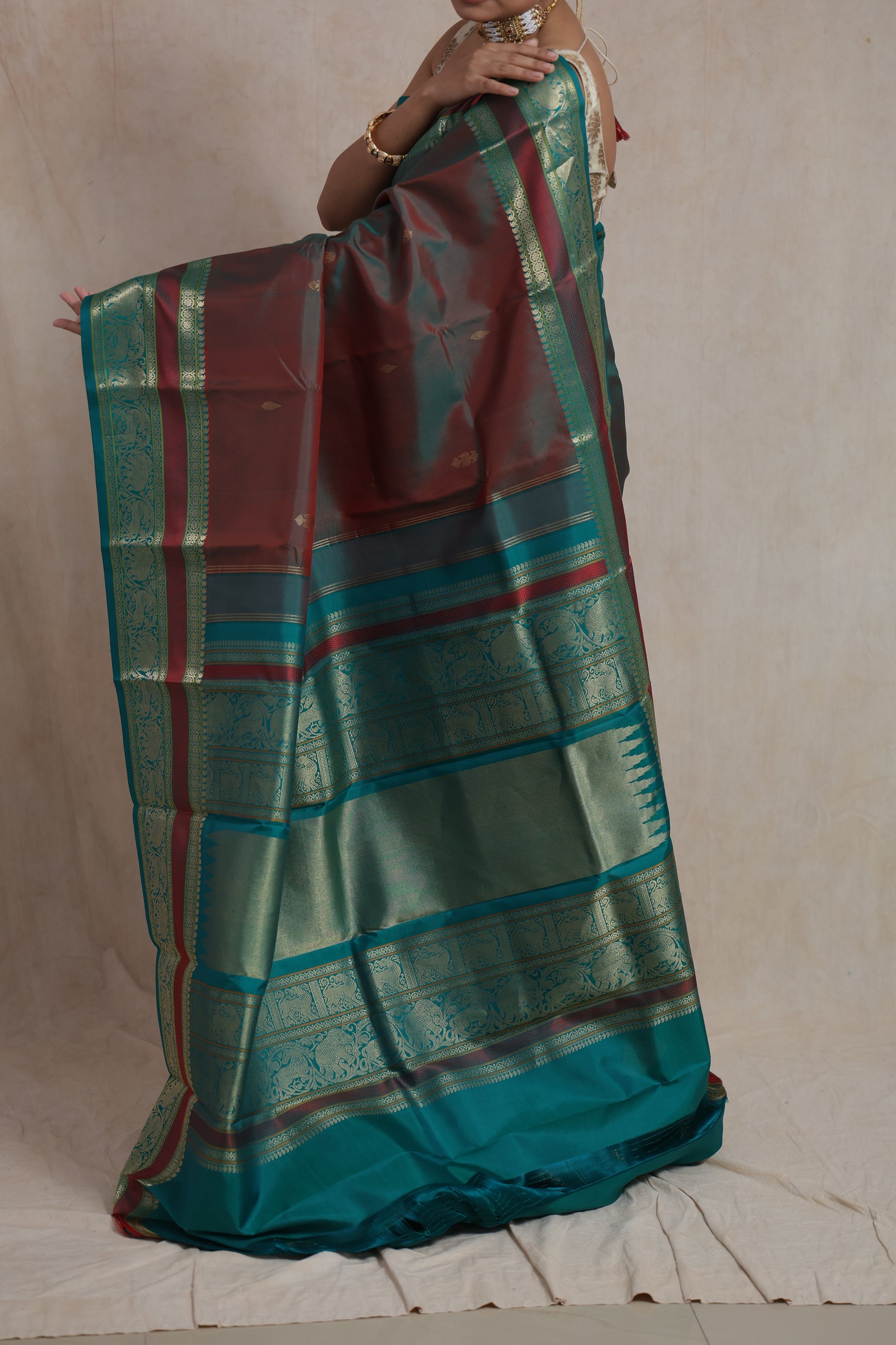 Traditional look in dual-tone maroon and teal Kanchiwaram silk saree with zari border