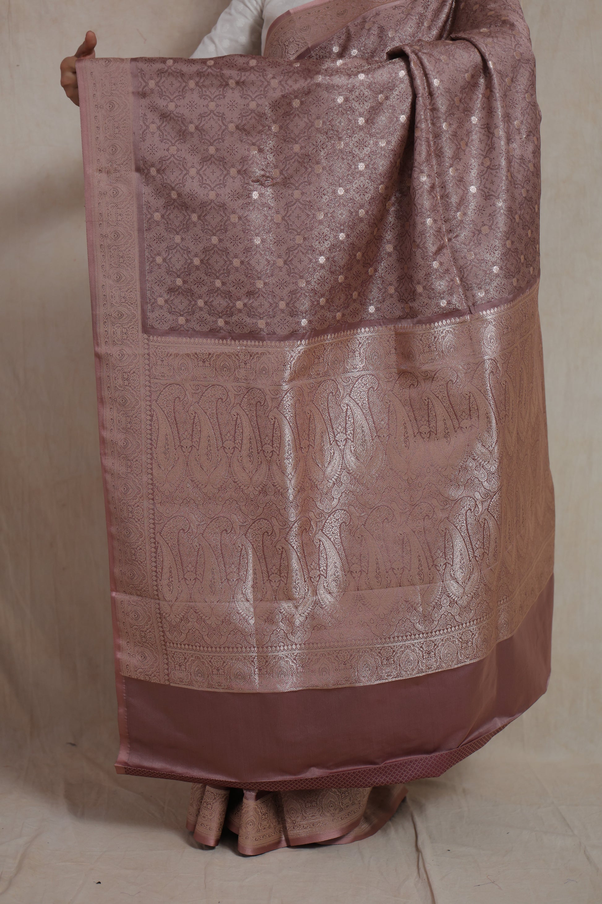 Detailed view of Banarasi woven pallu with intricate floral and paisley patterns on dusty rose saree
