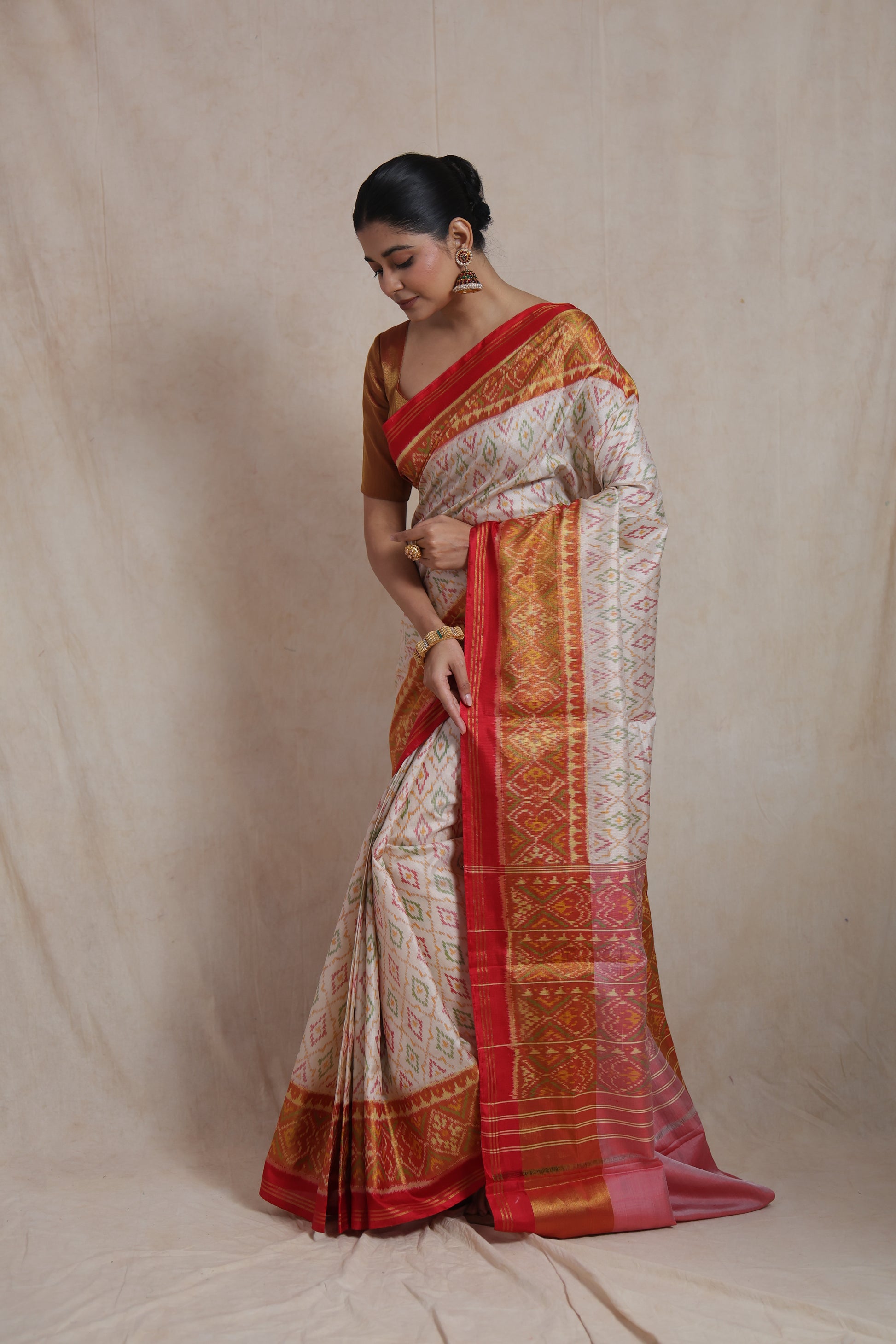 Elegant ivory white Patola silk saree showcasing traditional ikat-inspired motifs and heritage weaving
