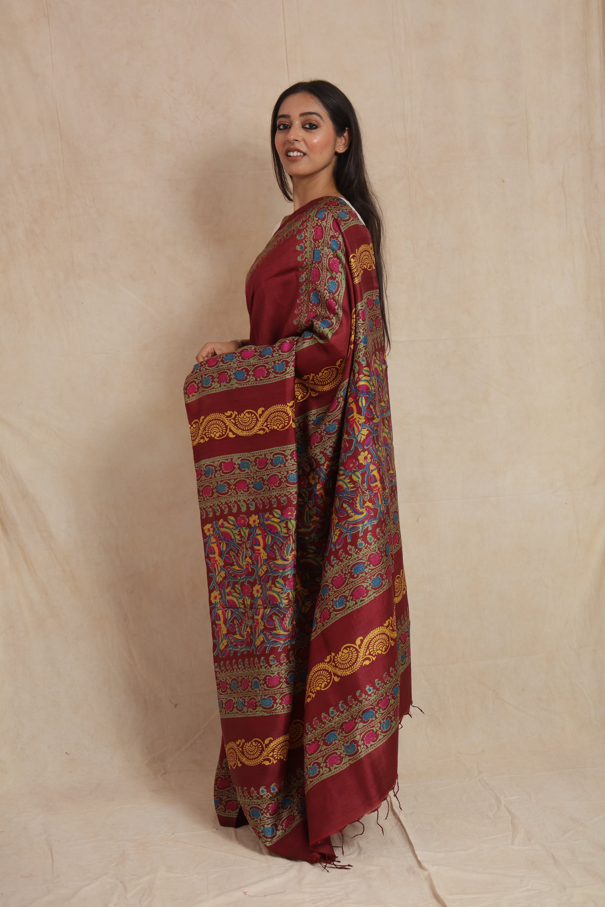 Side profile of deep maroon Batik silk saree with colorful handcrafted motifs