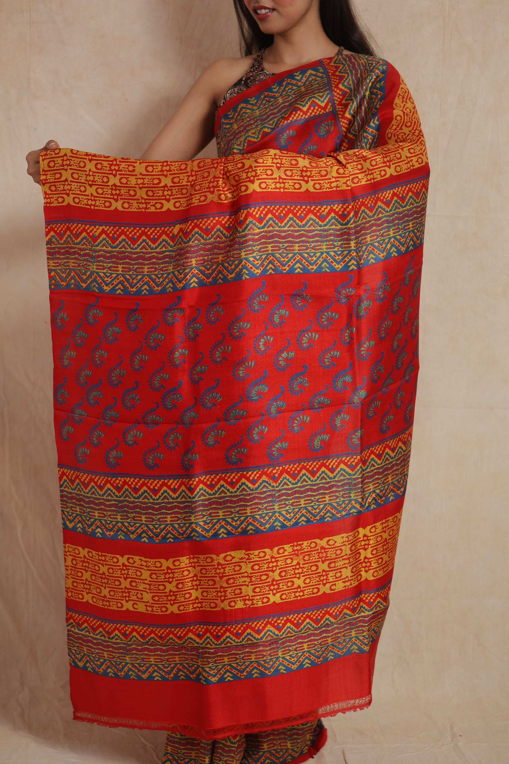 Model wearing royal red Batik silk saree with paisley and geometric motifs