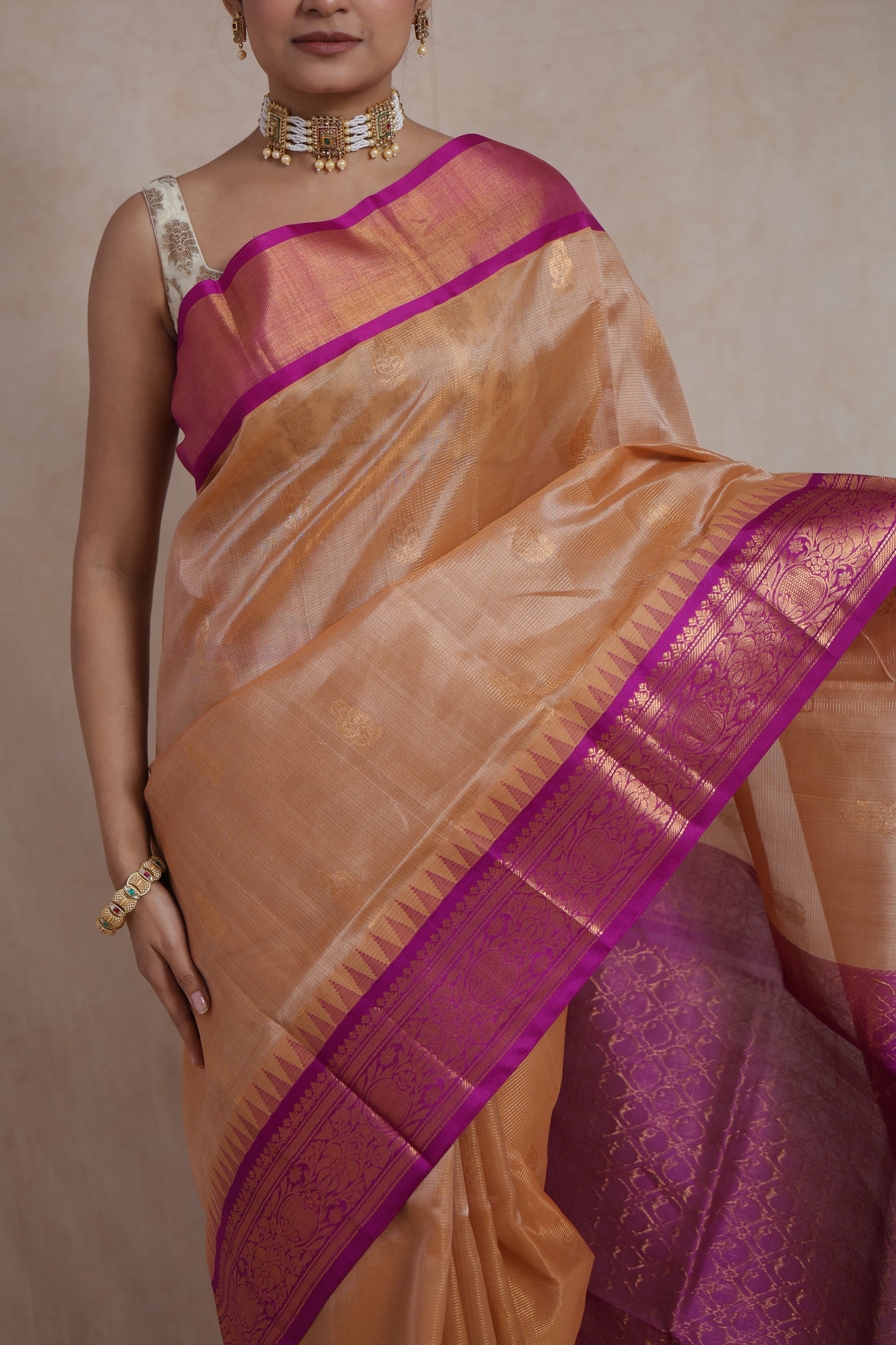 Close-up of golden beige Kanchipuram Sico saree with intricate woven motifs and magenta