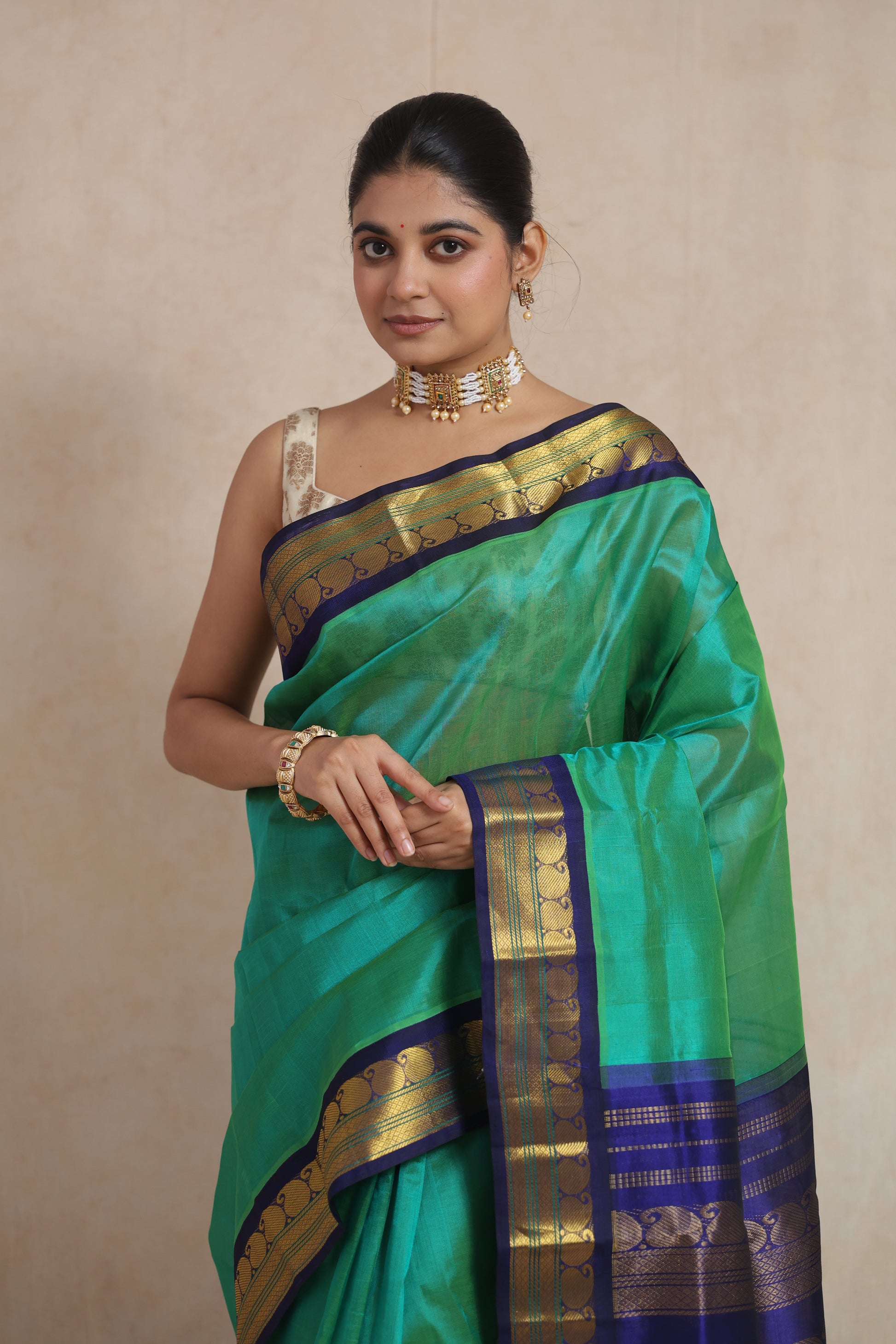 Portrait view of handwoven emerald green Kanchipuram Sico saree with blue zari woven border