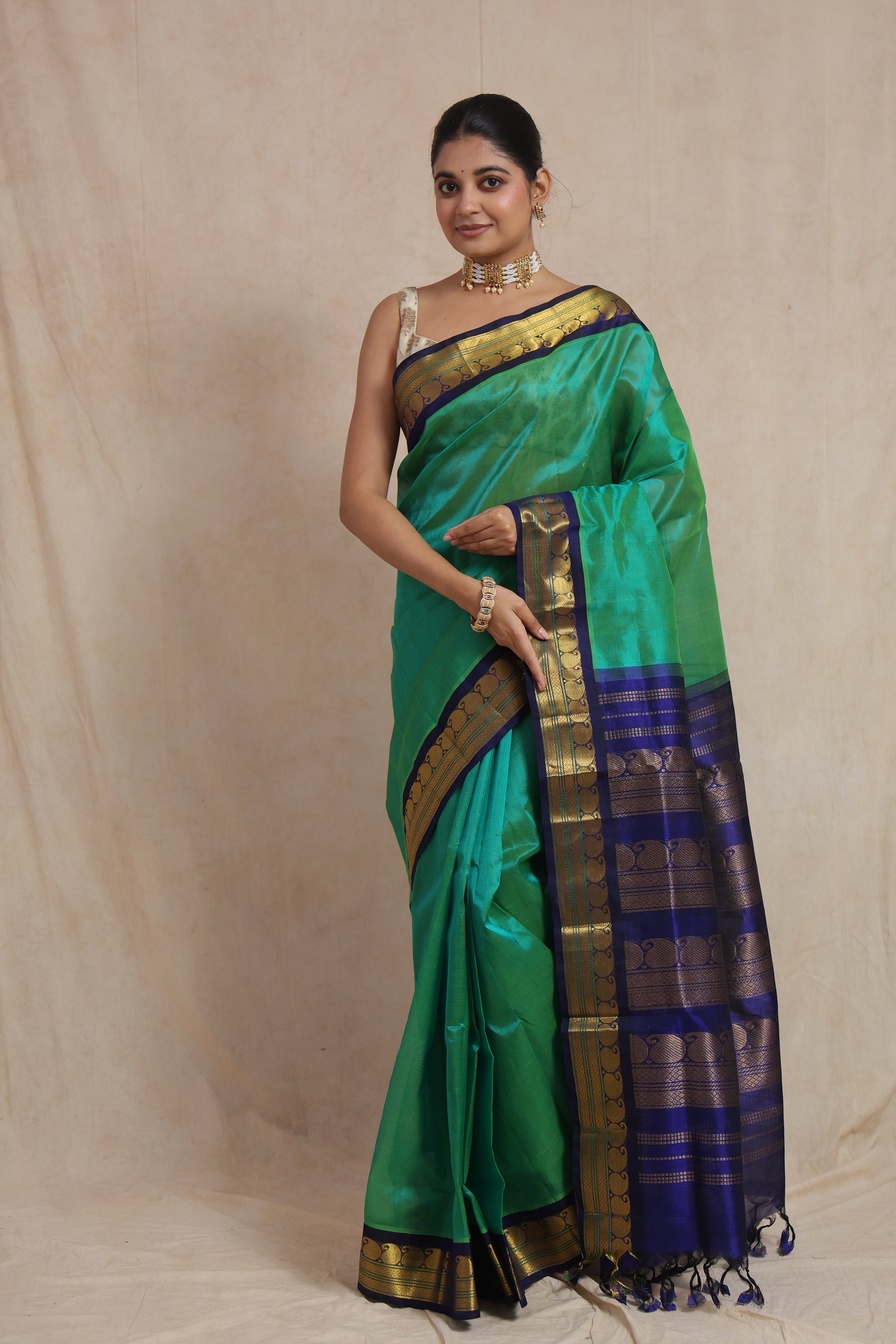 Full view of elegant emerald green Kanchipuram Sico saree with royal blue contrast border