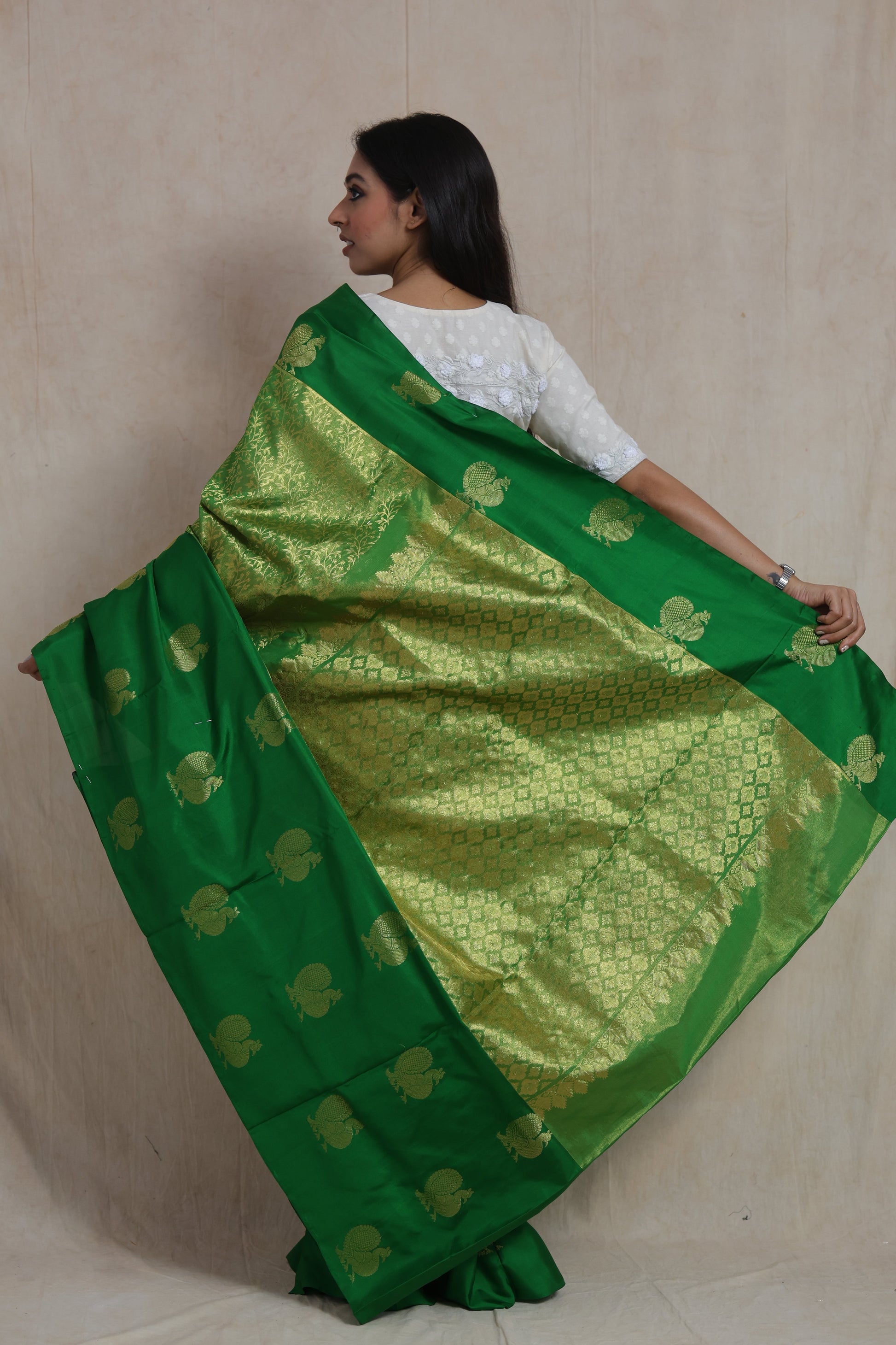 Back view of emerald green Kanjivaram silk saree featuring rich brocade woven pallu and peacock motifs