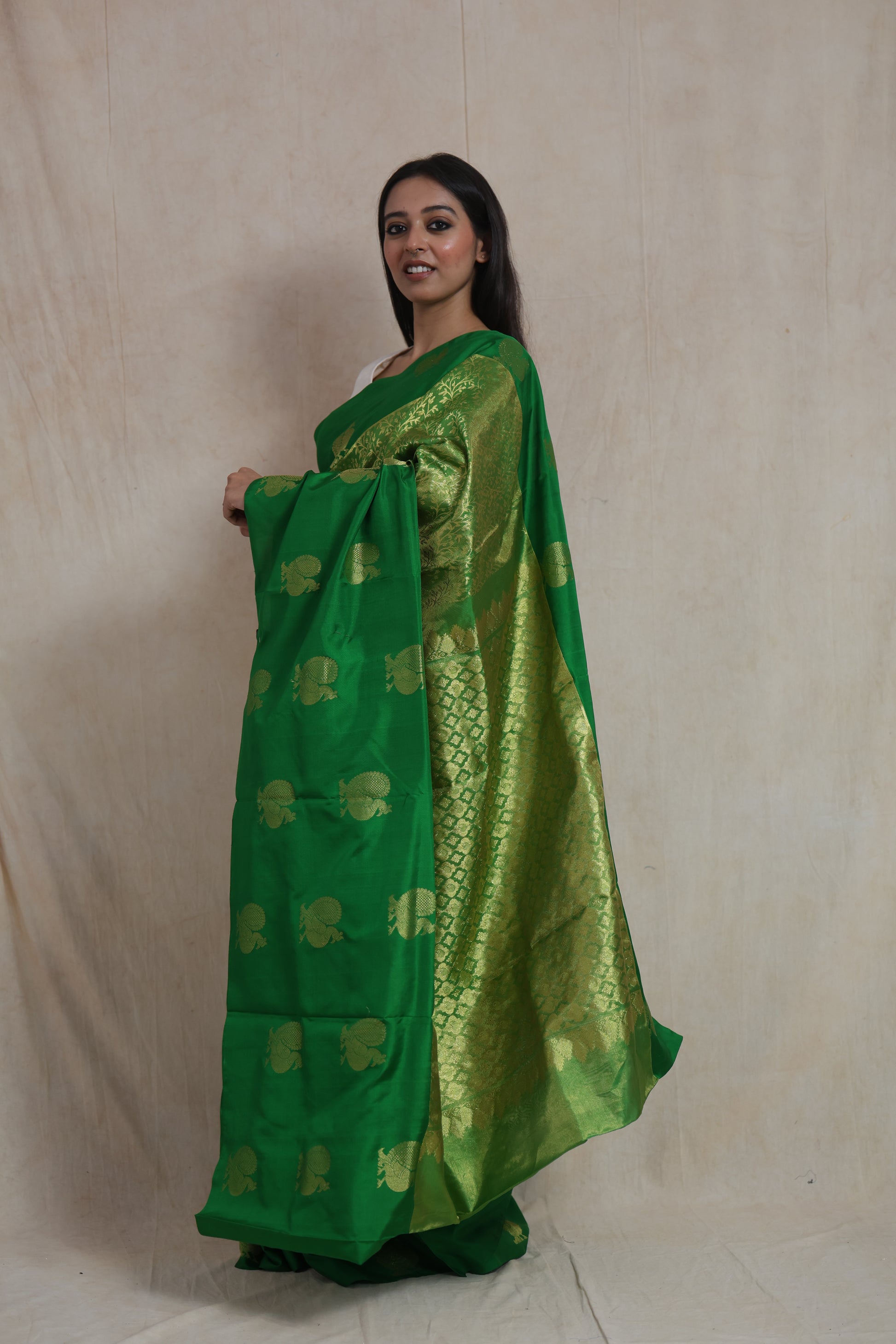 Side profile of emerald green Kanjivaram silk saree highlighting the richly woven pallu and traditional craftsmanship