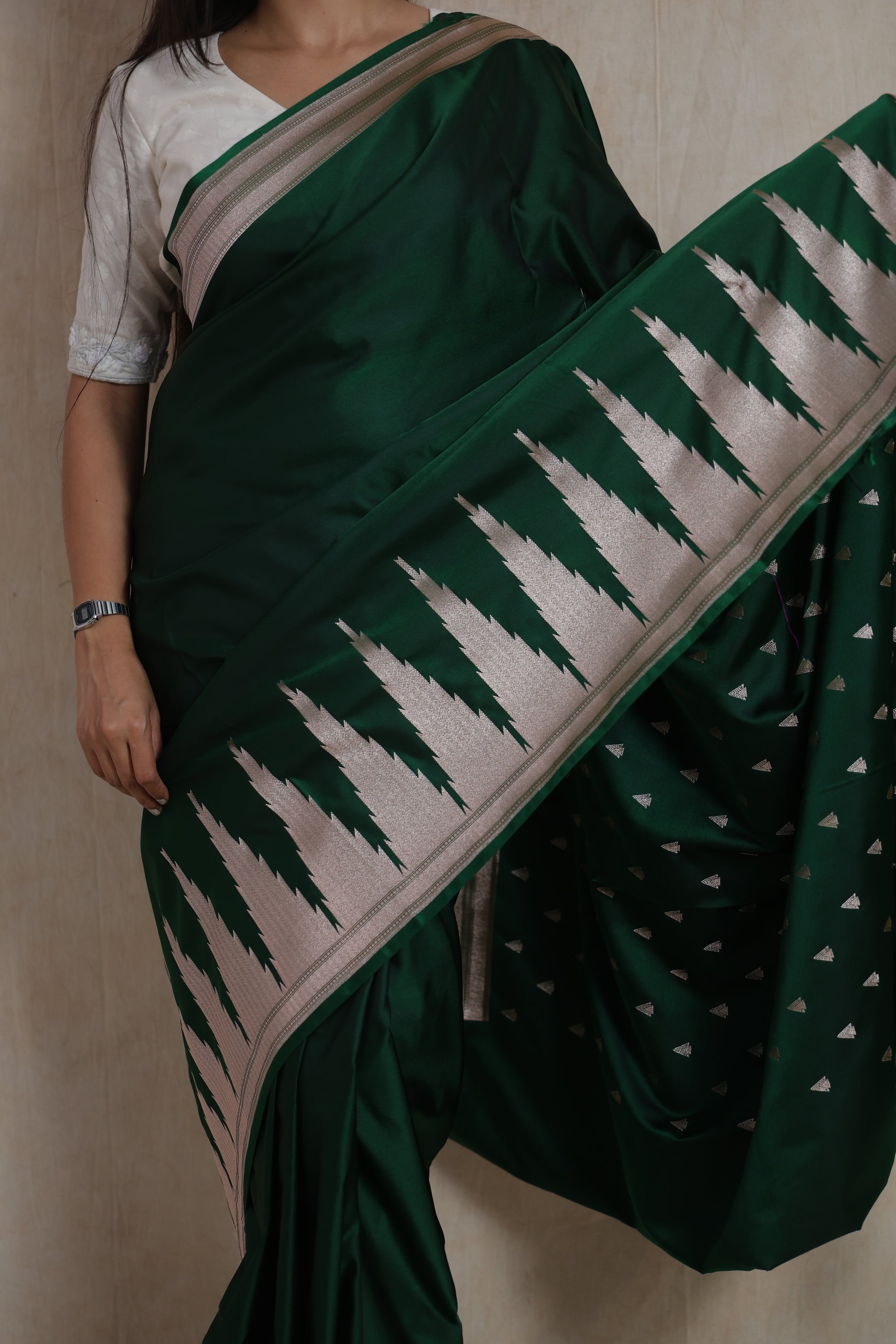 Close-up of emerald green Banarasi art silk saree featuring silver woven temple-inspired border