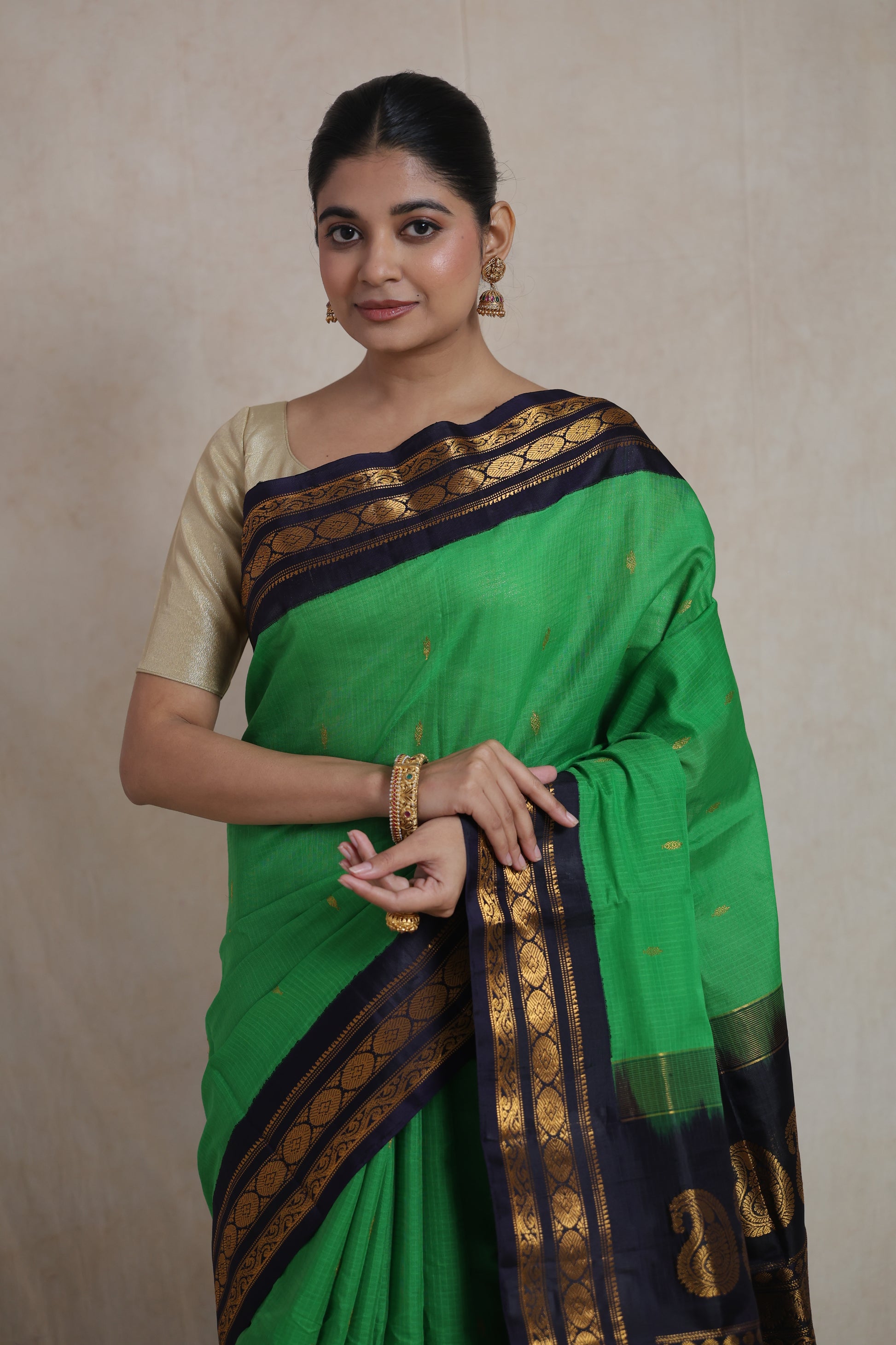 Front portrait of emerald green Gadwal Sico saree with zari woven border