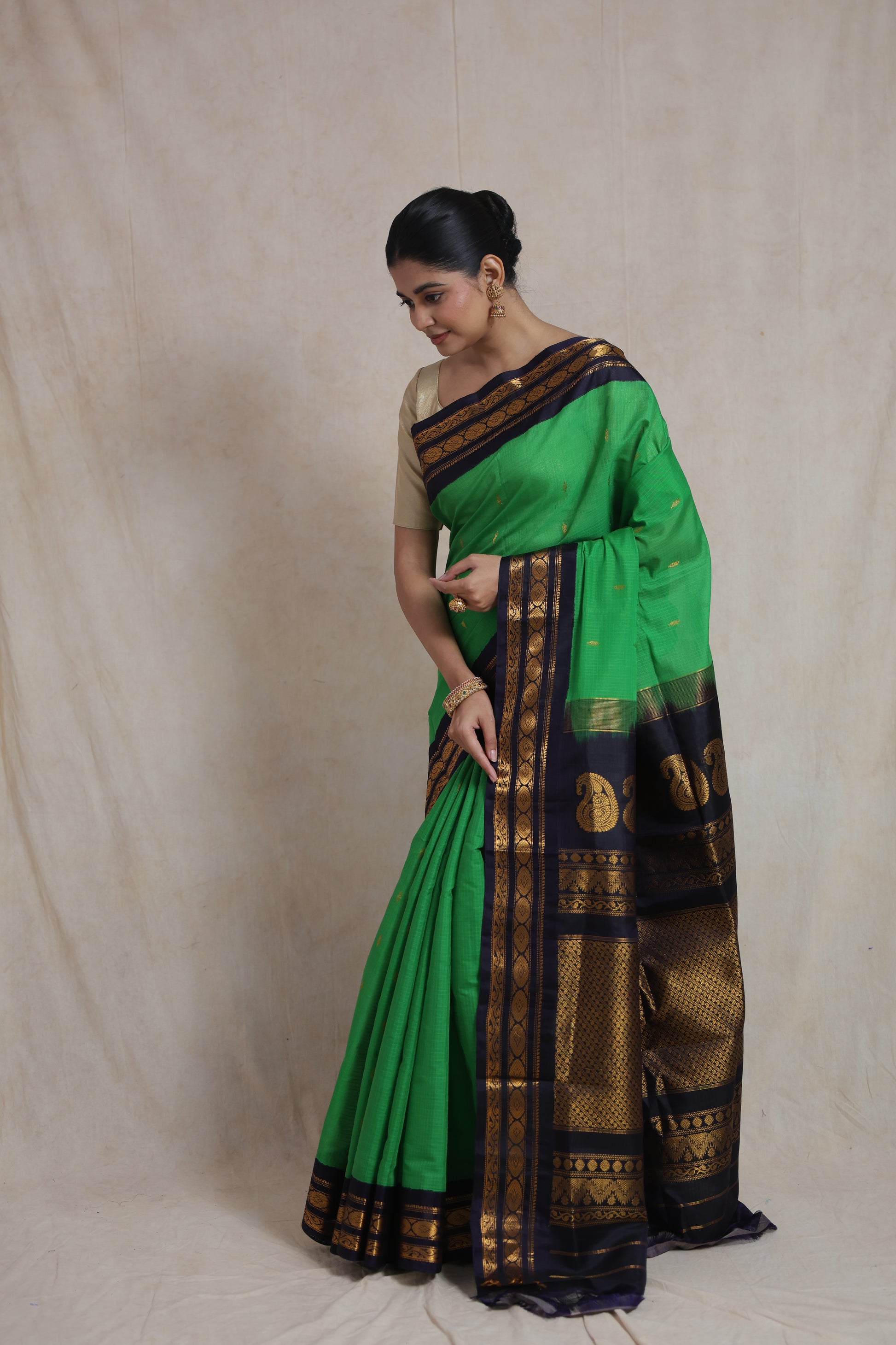 Model wearing emerald green Gadwal Sico saree with navy blue zari border