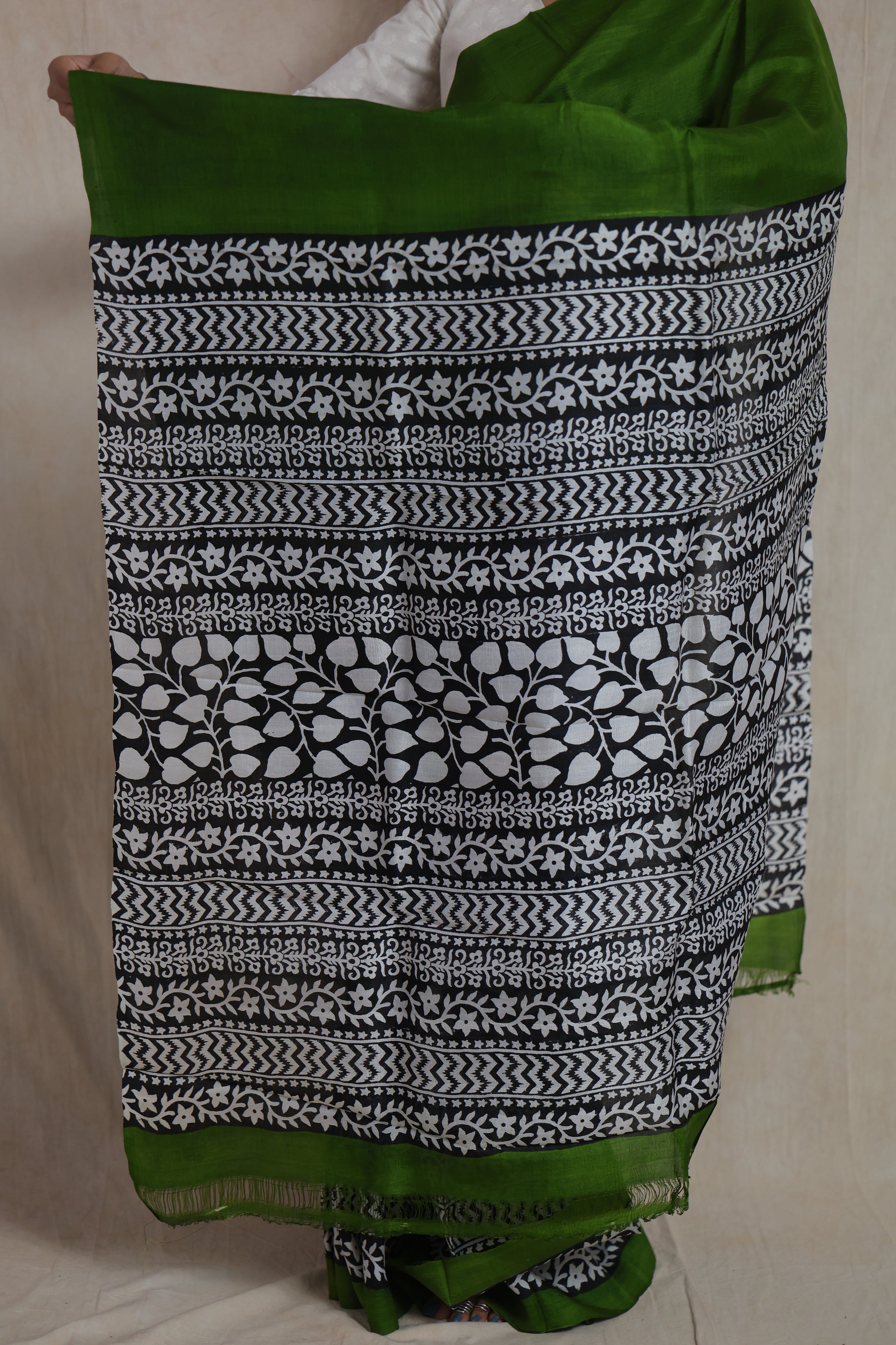 Detailed view of emerald green Garad handloom silk saree with black and white traditional printed pallu