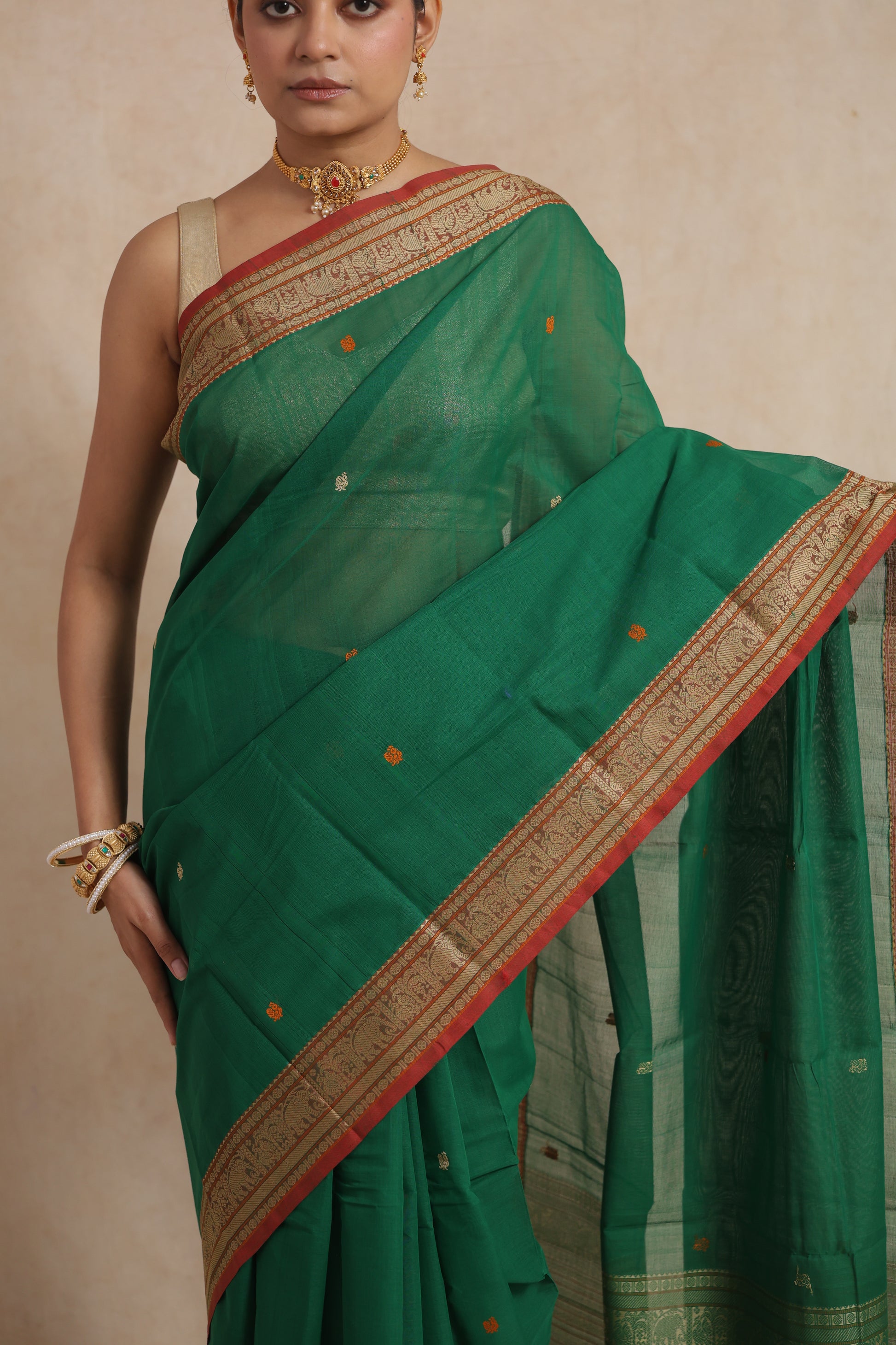 Detailed border and buttas on emerald green Kanchipuram cotton saree