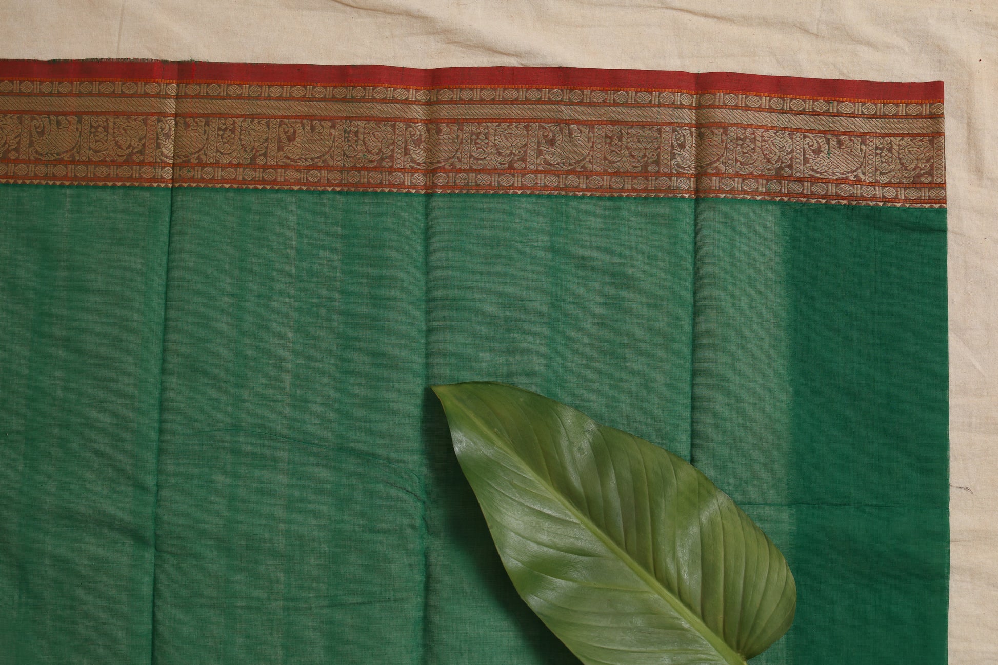 Flatlay detail of emerald green Kanchipuram cotton saree border