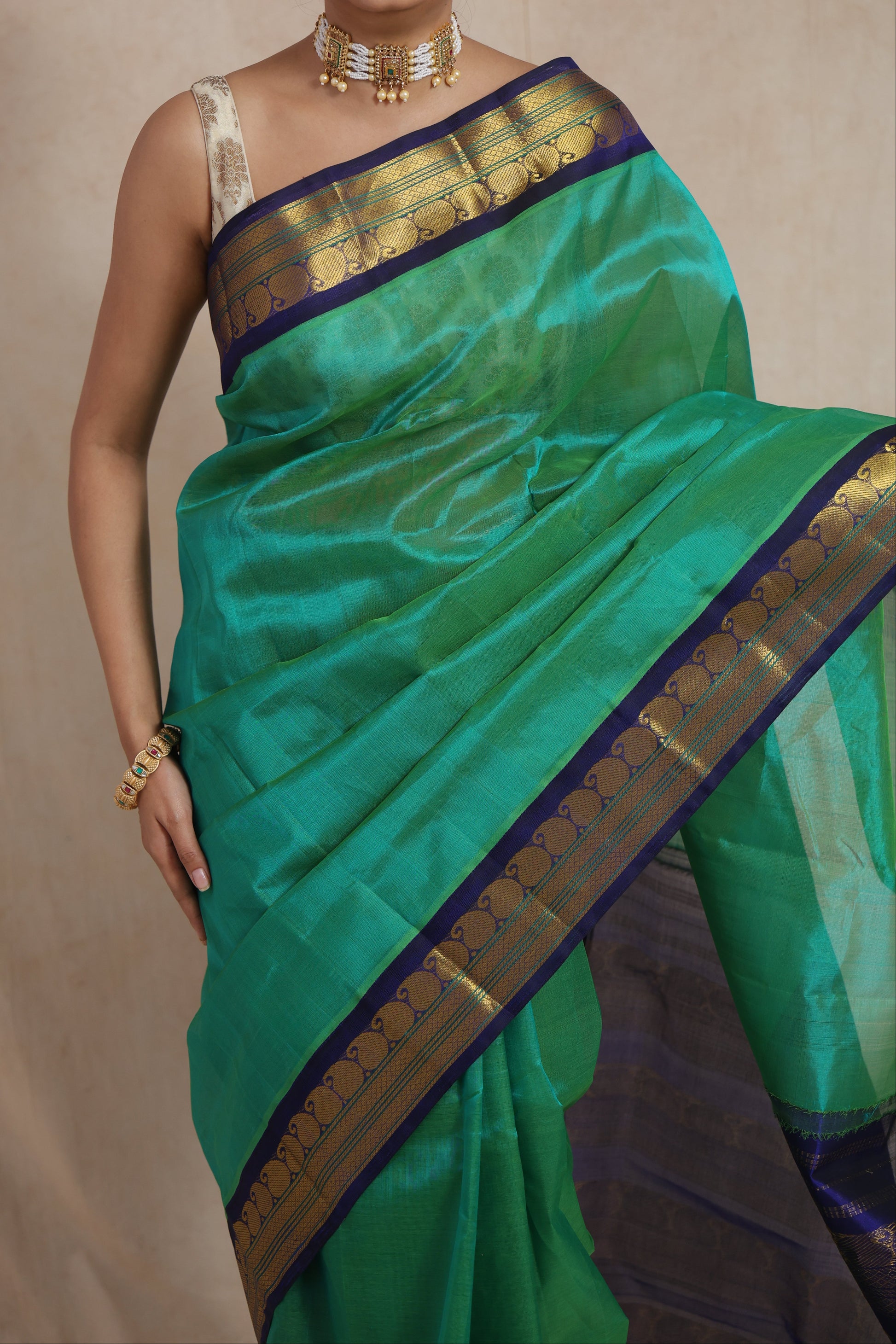 Portrait view of handwoven emerald green Kanchipuram Sico saree with blue zari woven border