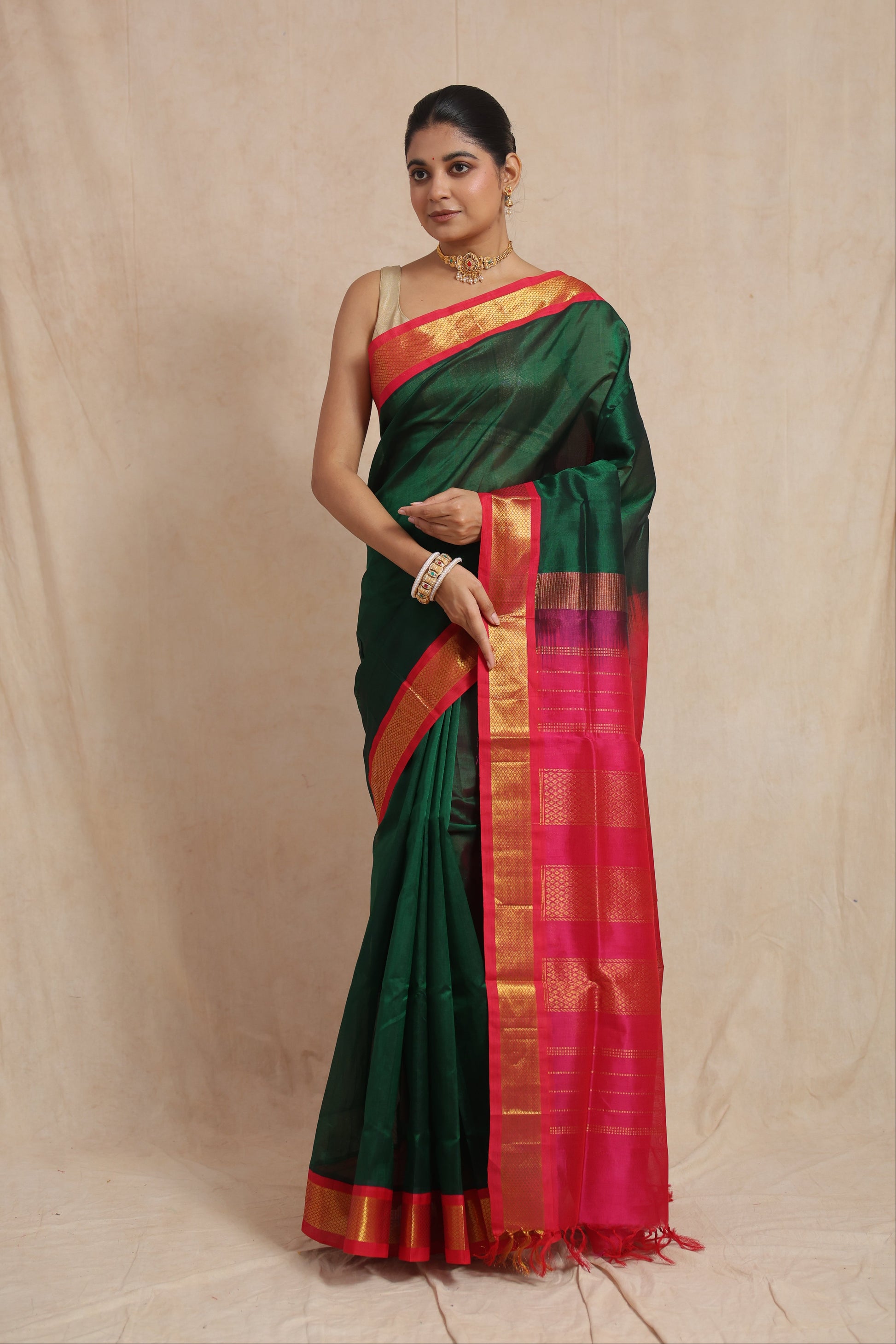 Full drape view of emerald green Kanchipuram Sico saree with rani pink zari border