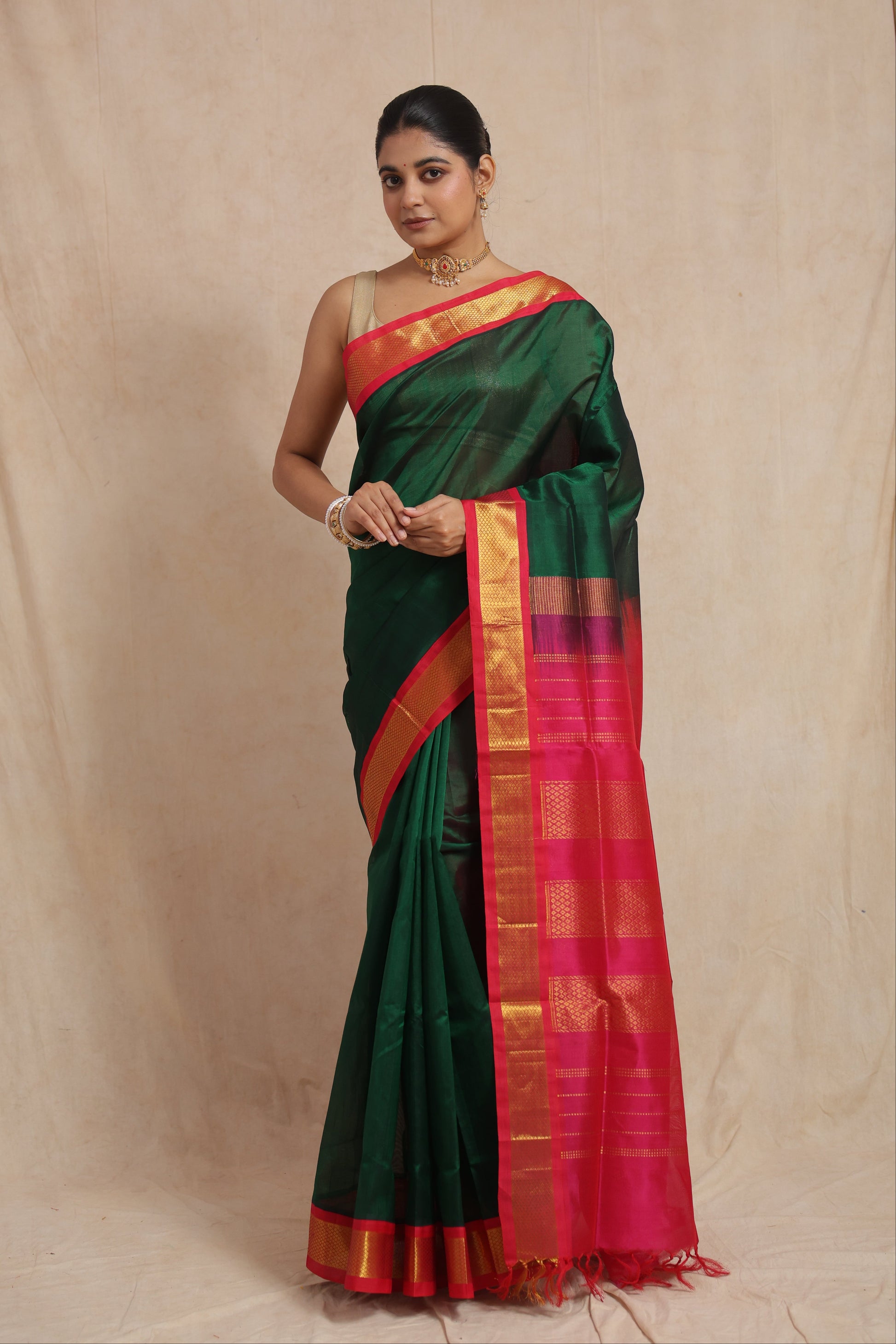 Model wearing emerald green Kanchipuram Sico saree with vibrant pink pallu