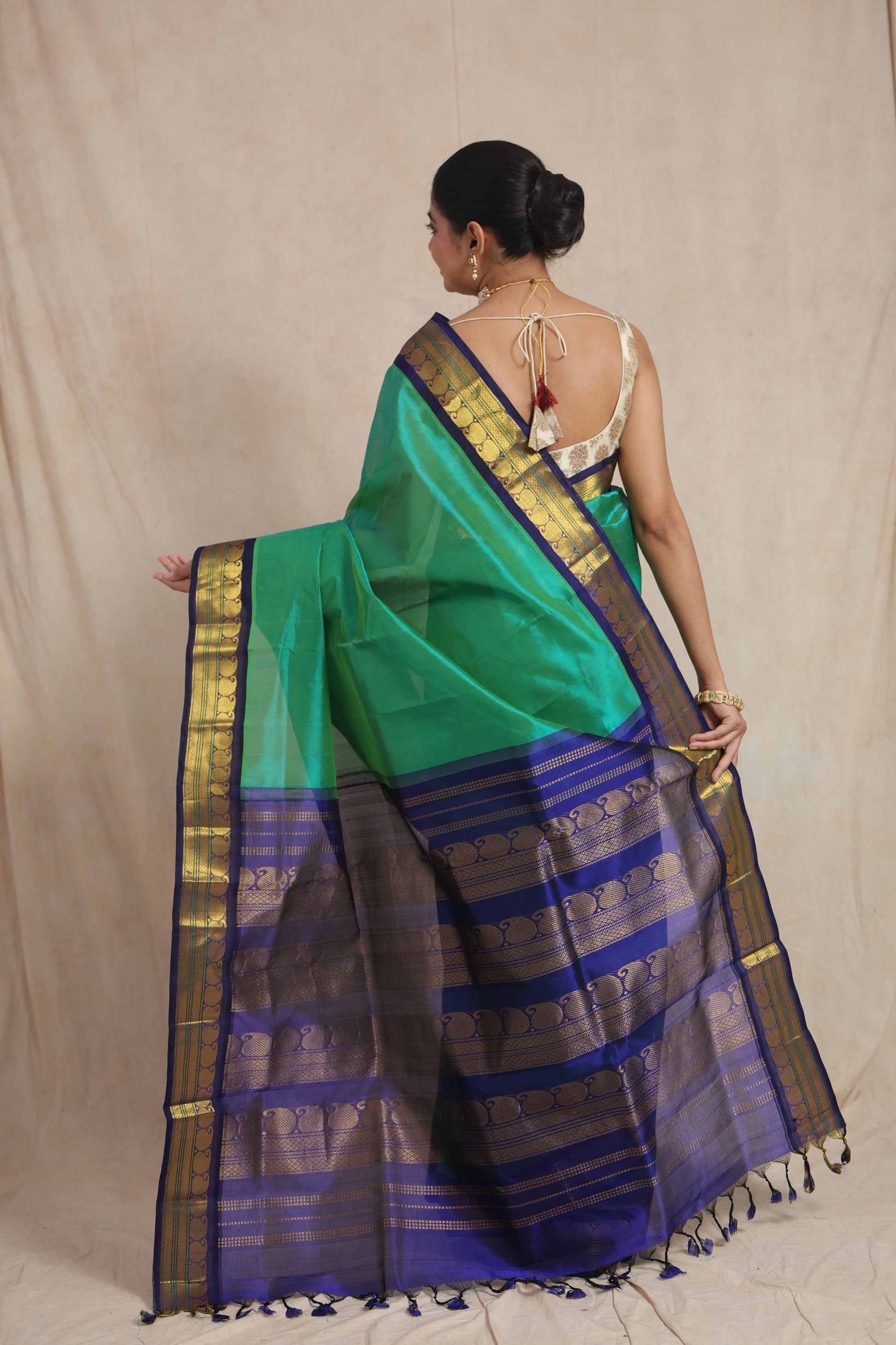 Back view of emerald green Kanchipuram Sico saree with royal blue woven pallu and tassels