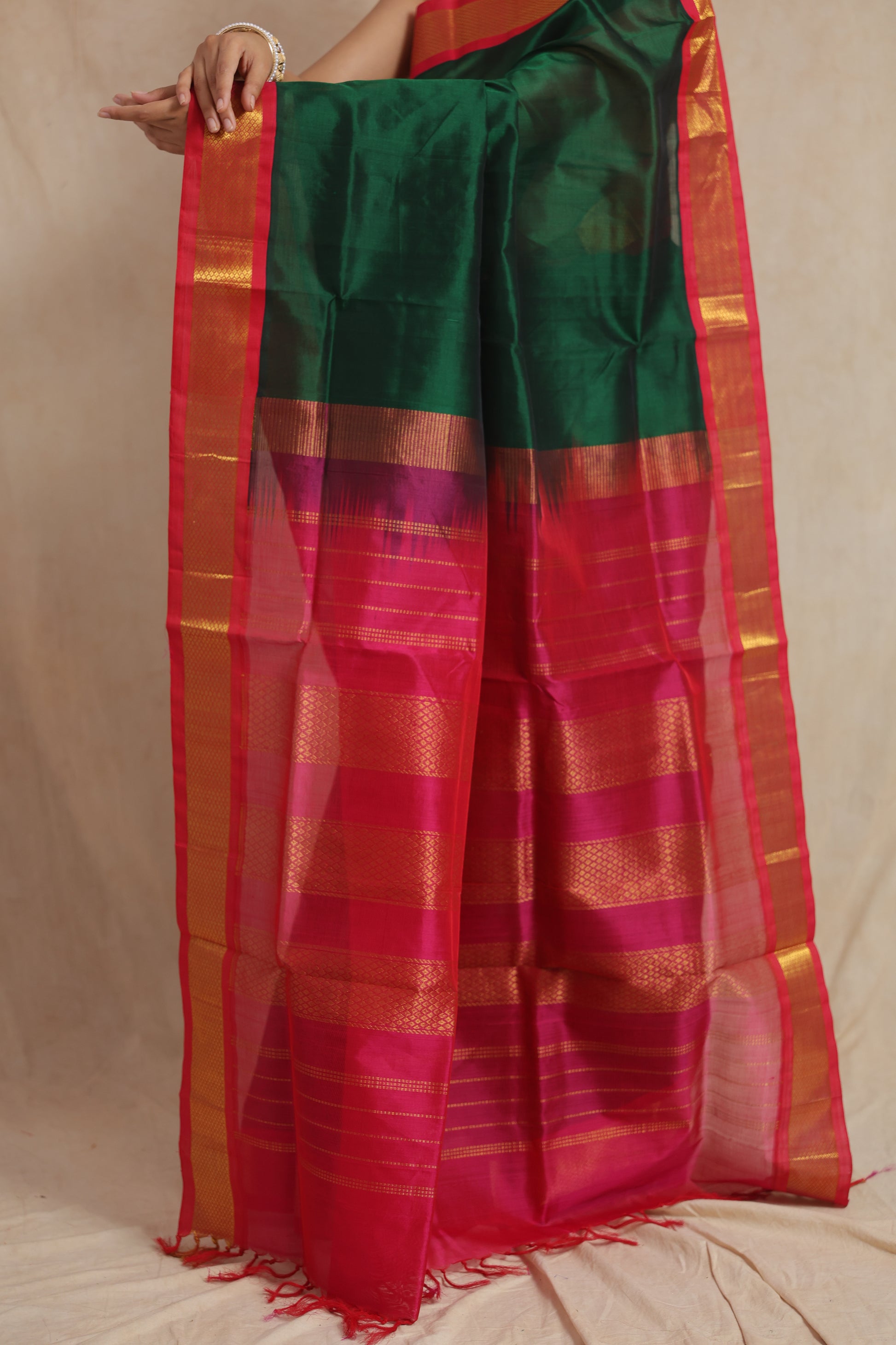 Model wearing emerald green Kanchipuram Sico saree with vibrant pink pallu