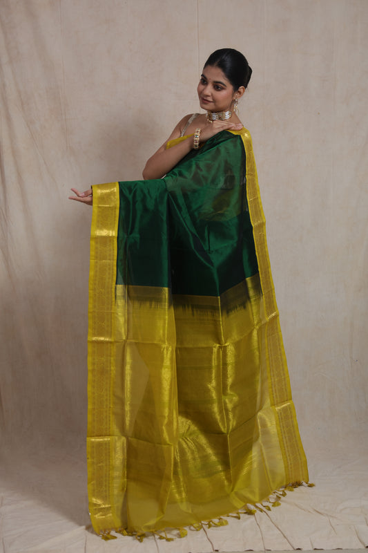 Model wearing emerald green Kanchipuram silk cotton saree with mustard zari border