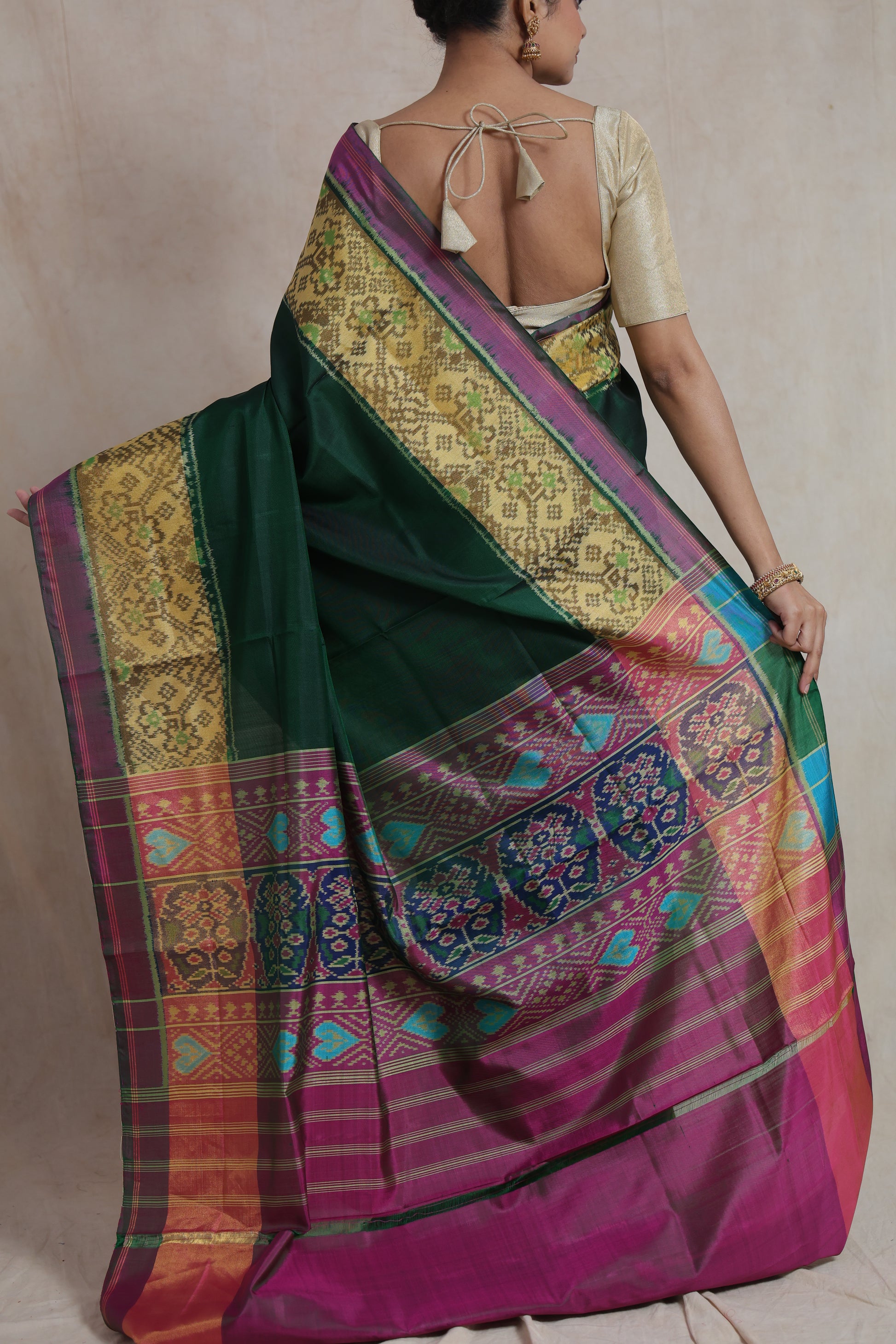 Back drape view of emerald green Patola silk saree with multicolor woven pallu