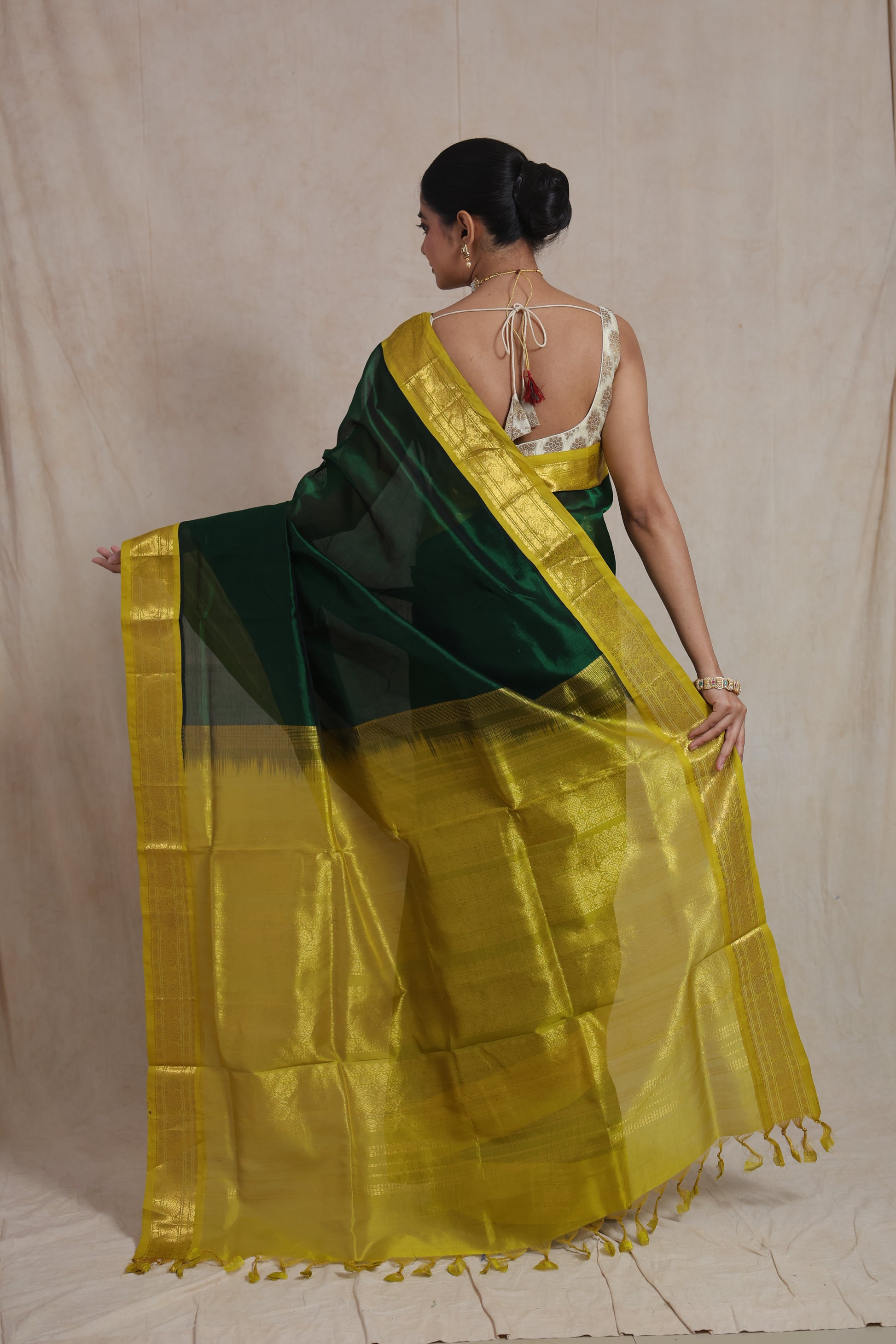 Festive drape of green silk cotton saree with golden mustard border