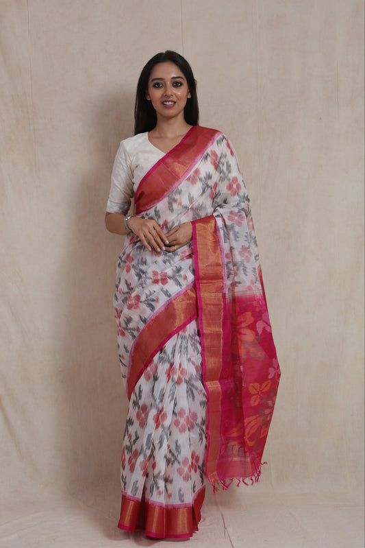 Full-length view of ivory Pochampally silk cotton saree showcasing floral motifs, pink border, and elegant drape