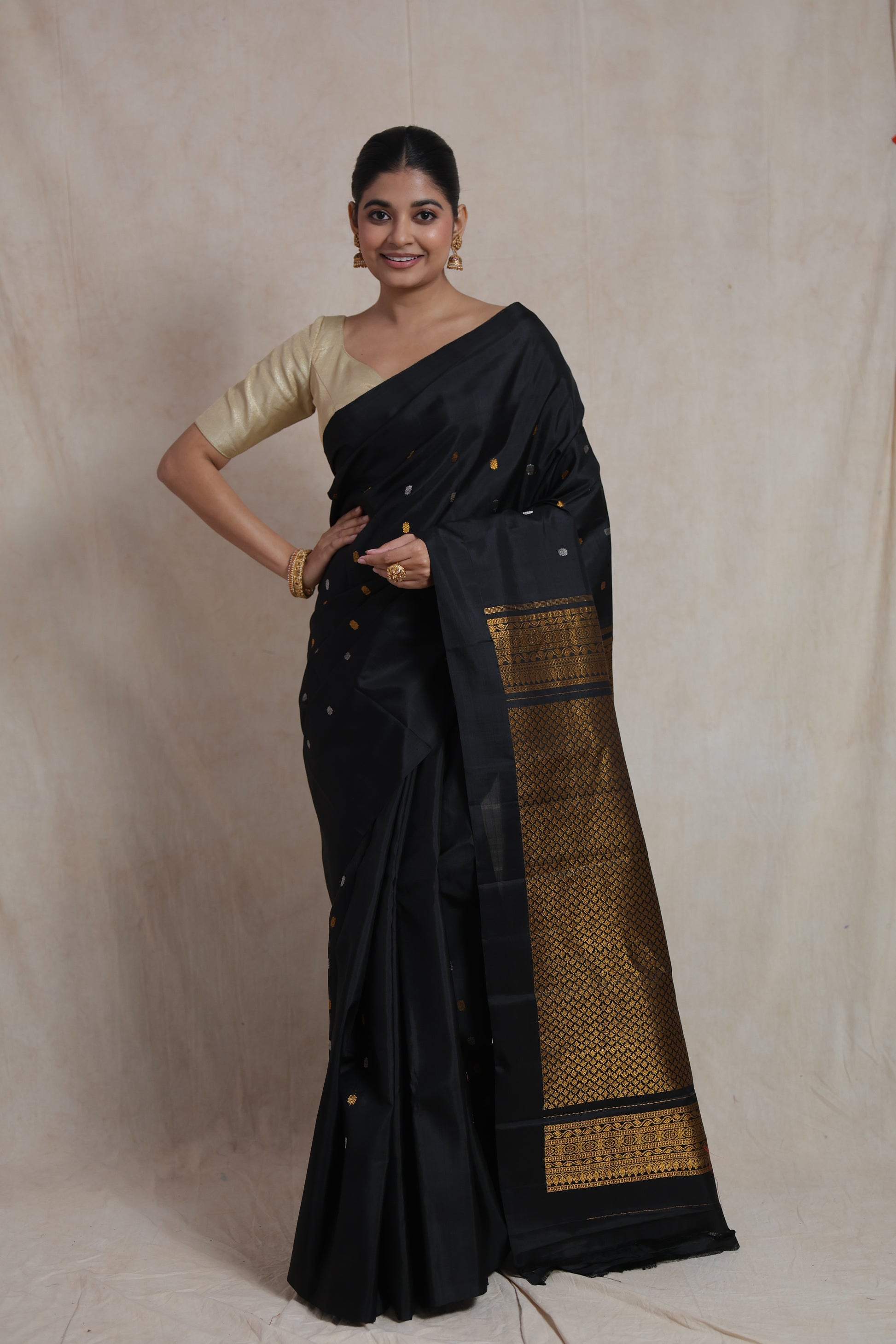 Model wearing black Gadwal silk saree with woven gold pallu