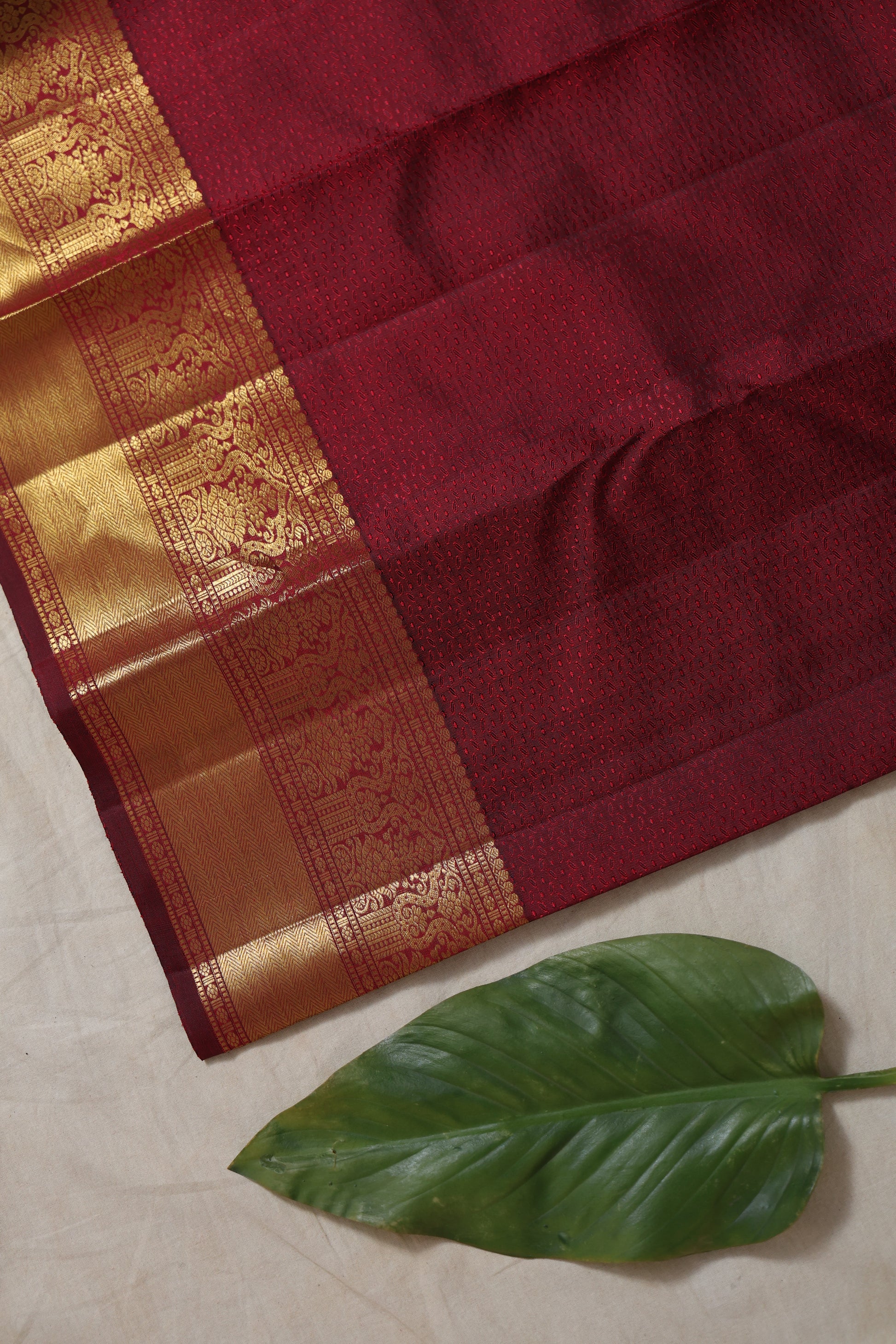 Detailed golden zari border of maroon Kanjivaram silk saree