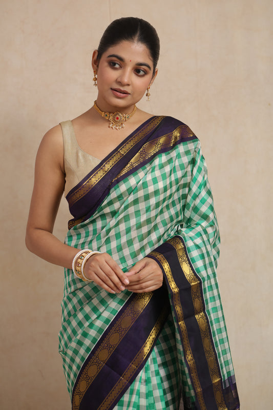 Elegant drape of green checked Kanchipuram Sico saree with rich woven detailing