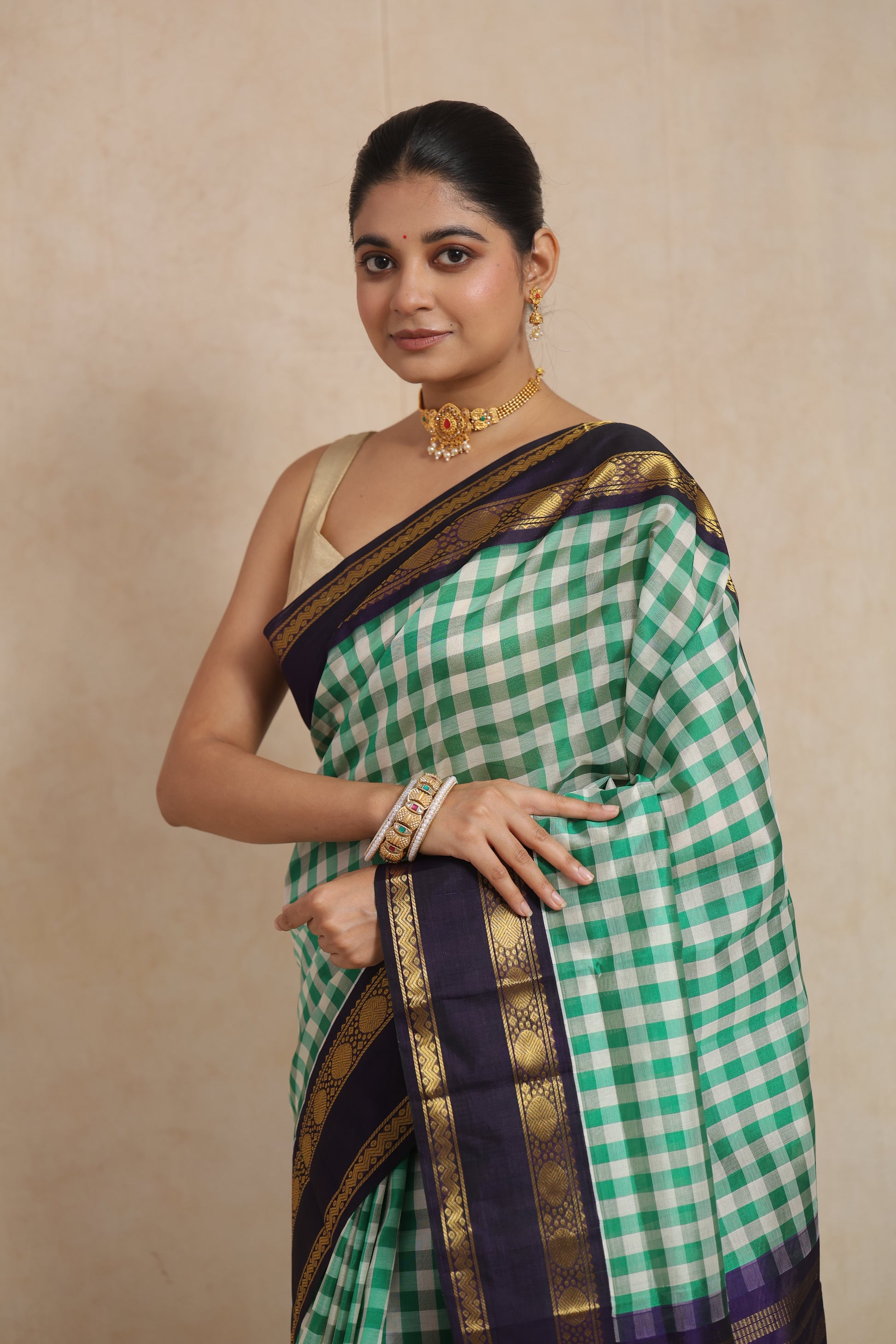 Portrait view of emerald green checked Kanchipuram Sico saree with traditional zari border