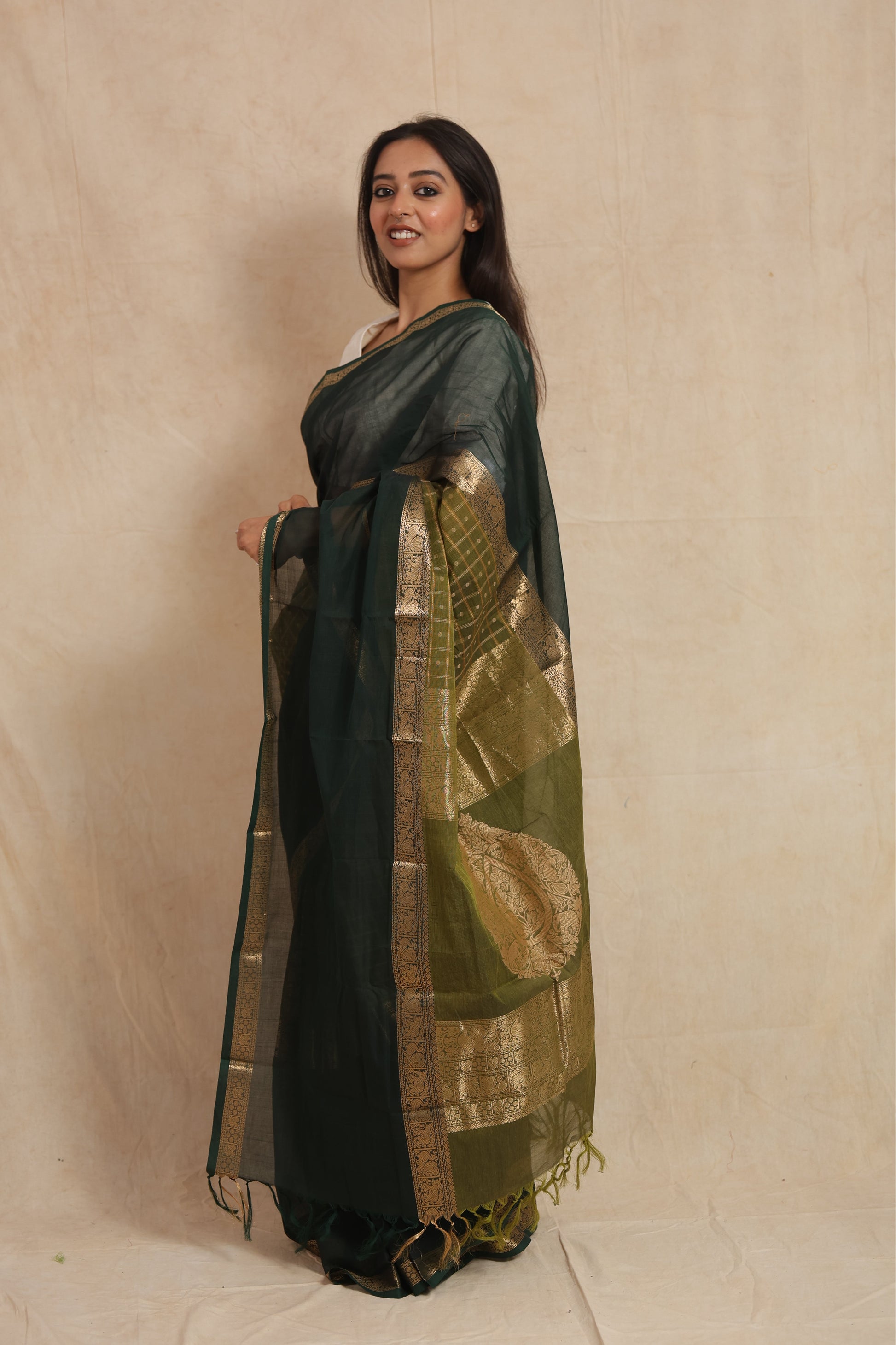 Side profile of deep green Kanchipuram cotton saree with golden woven border