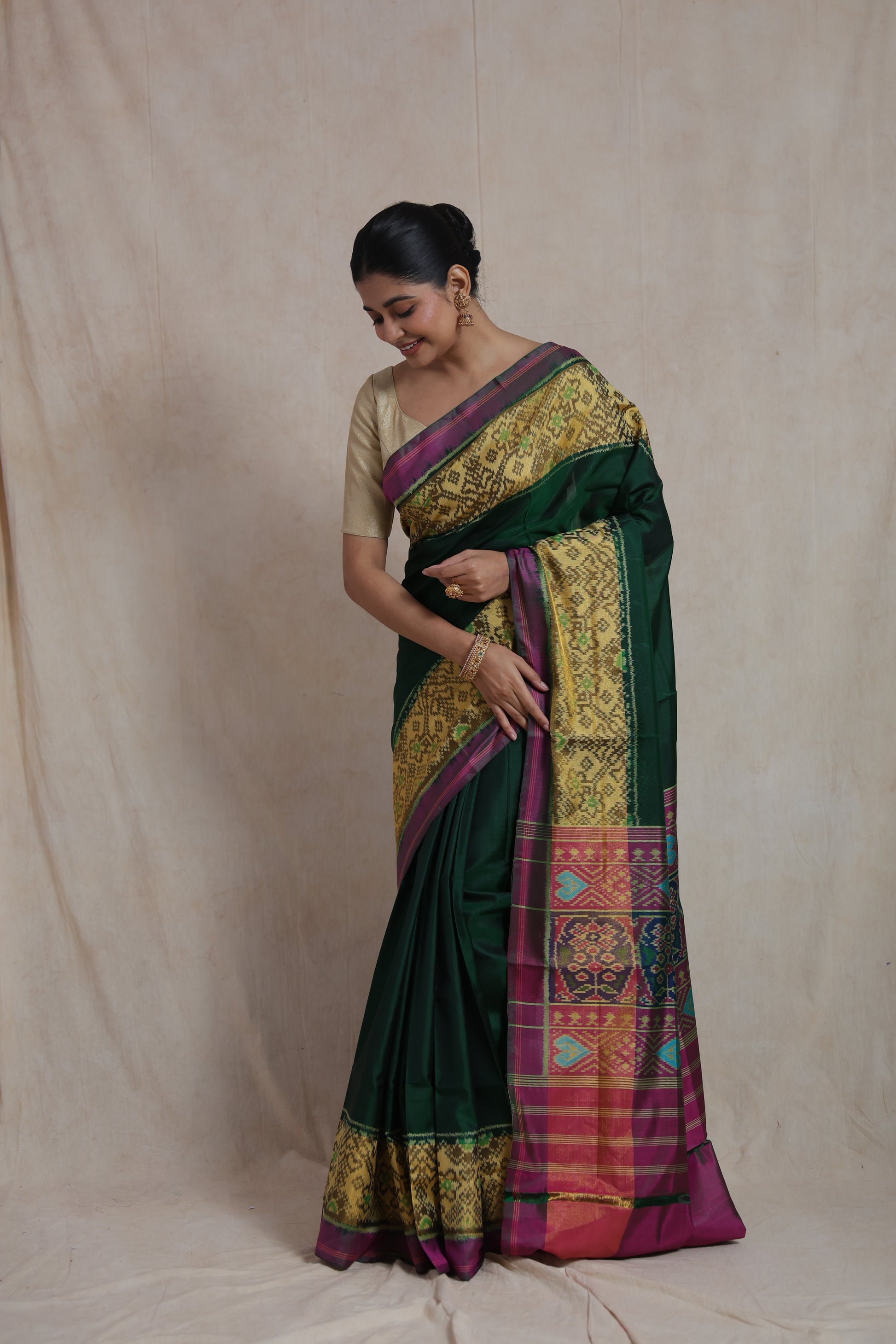 Side pose of green Patola silk saree with colorful woven pallu detailing