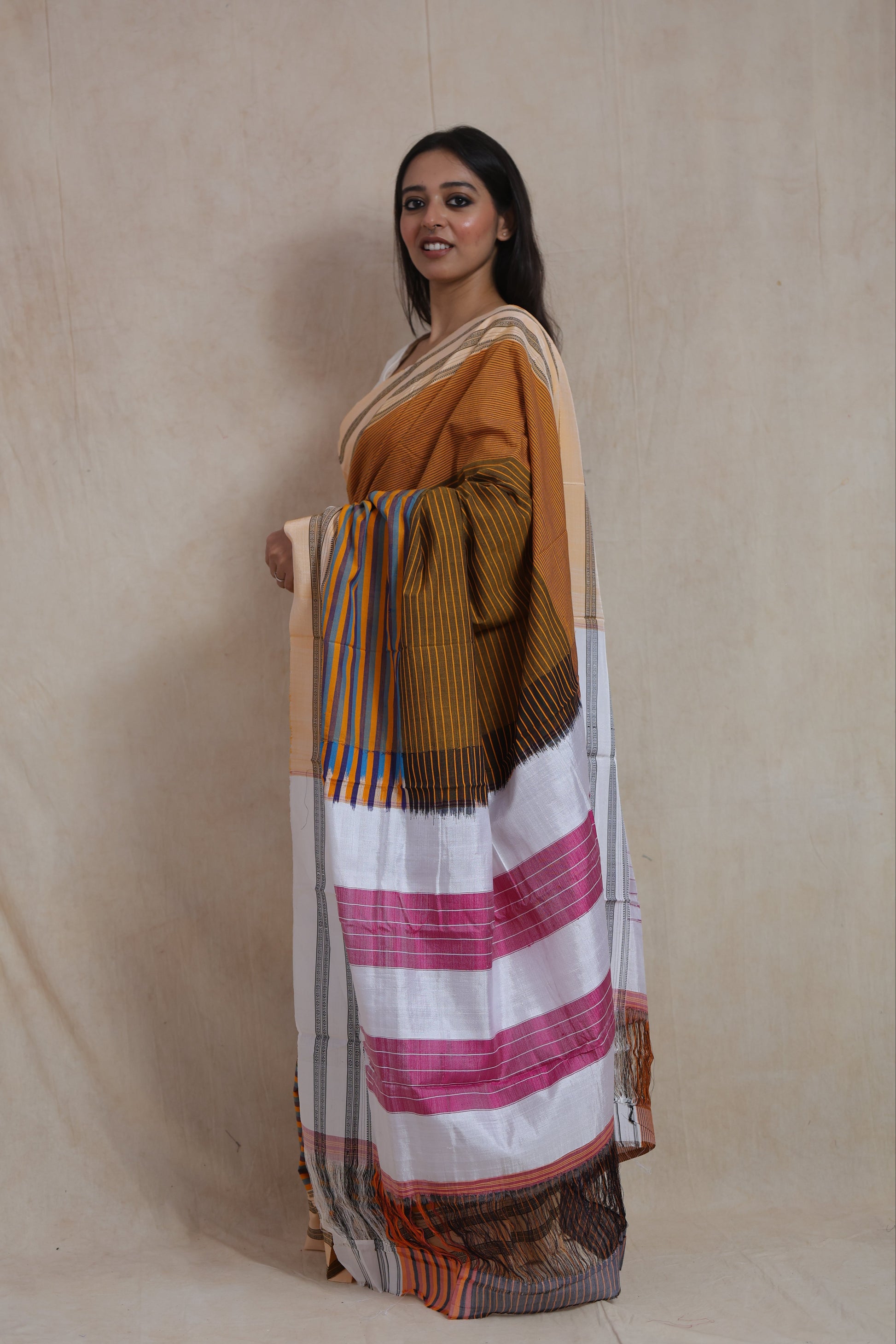 Side profile of handwoven Ilkal cotton saree featuring striped pallu and white panel with pink accents