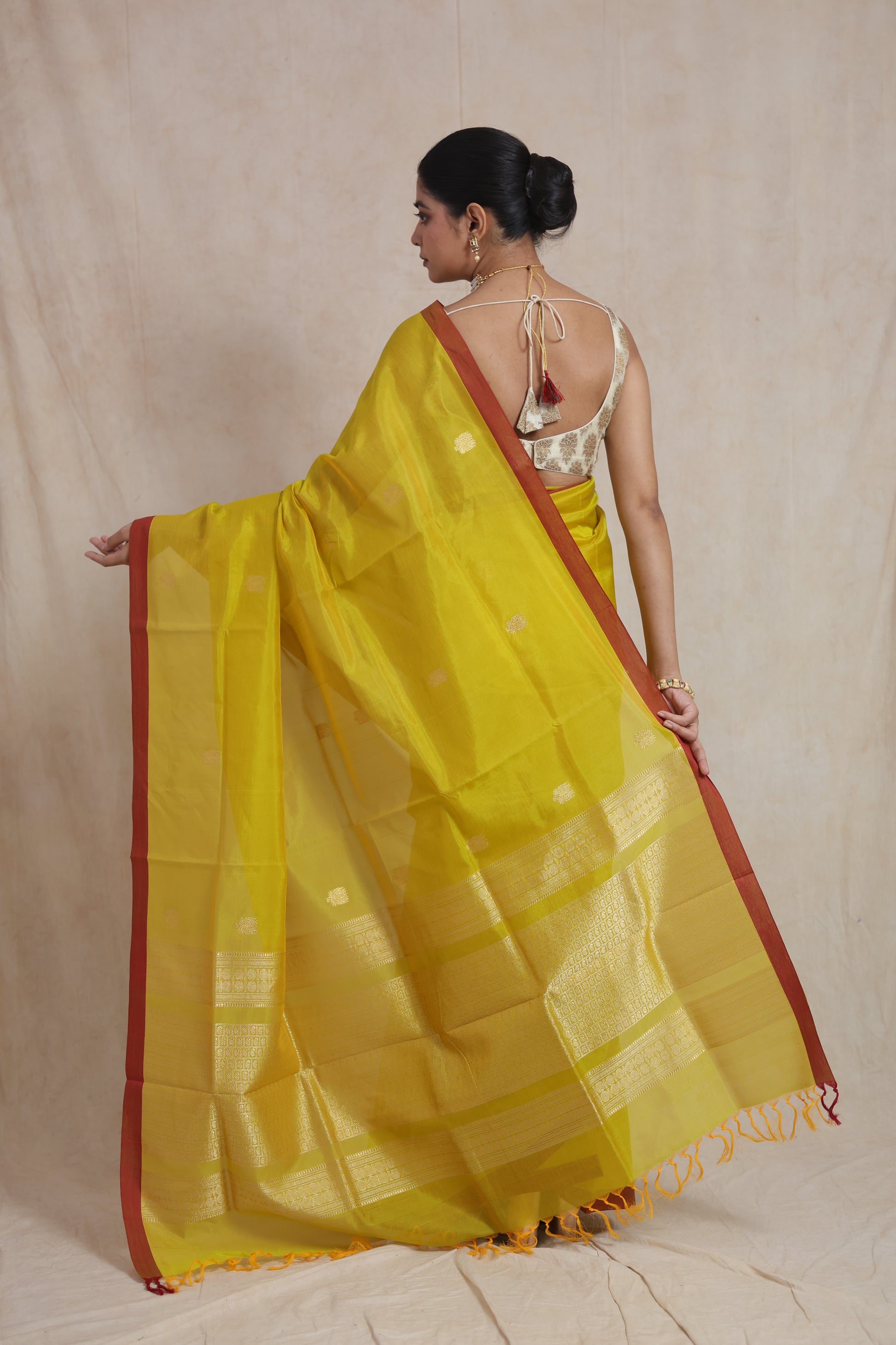 Back view of lime yellow Kanchipuram Sico saree with rust border and zari pallu