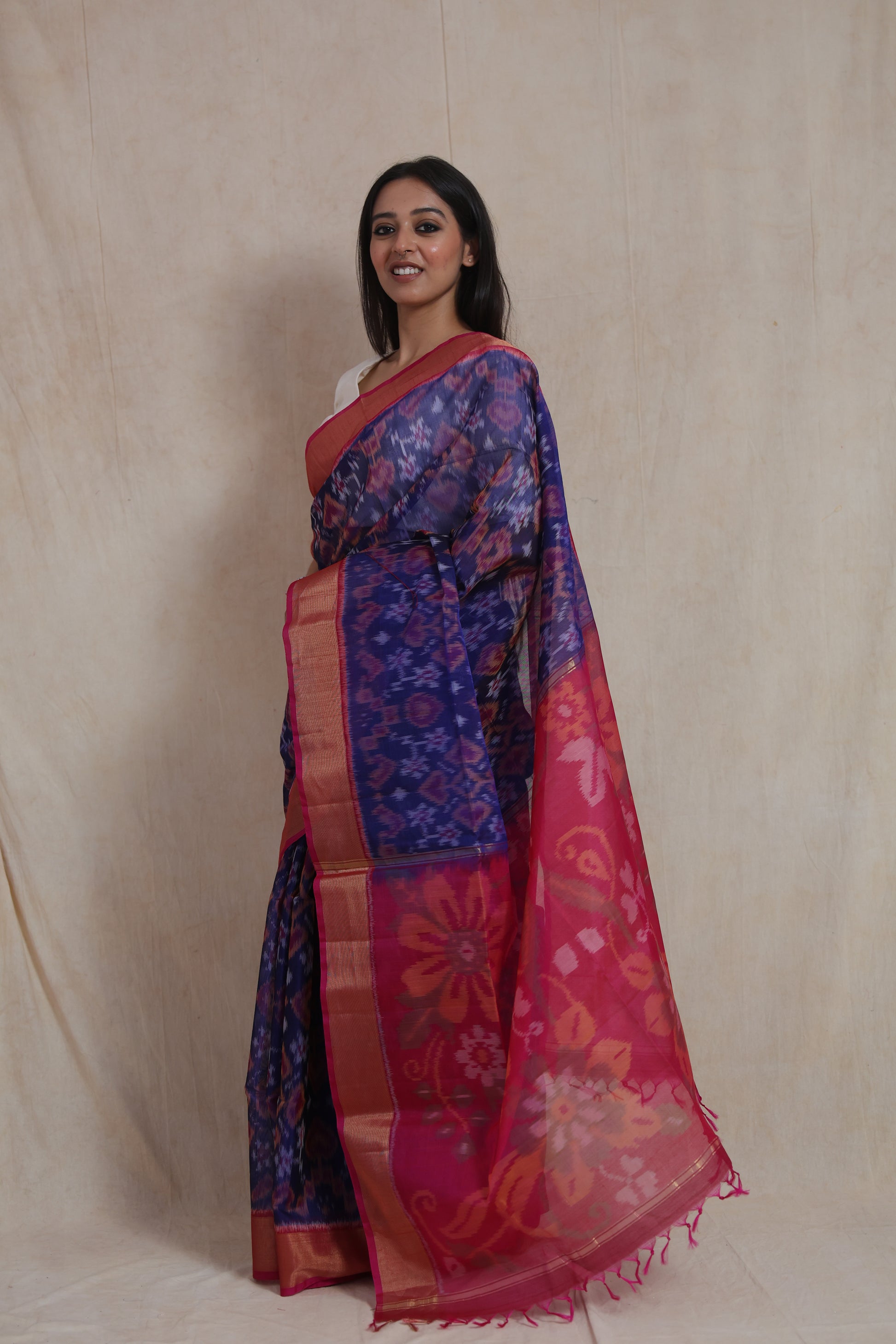 Side profile of indigo blue Pochampally silk cotton saree featuring contrast pink border and floral woven pallu