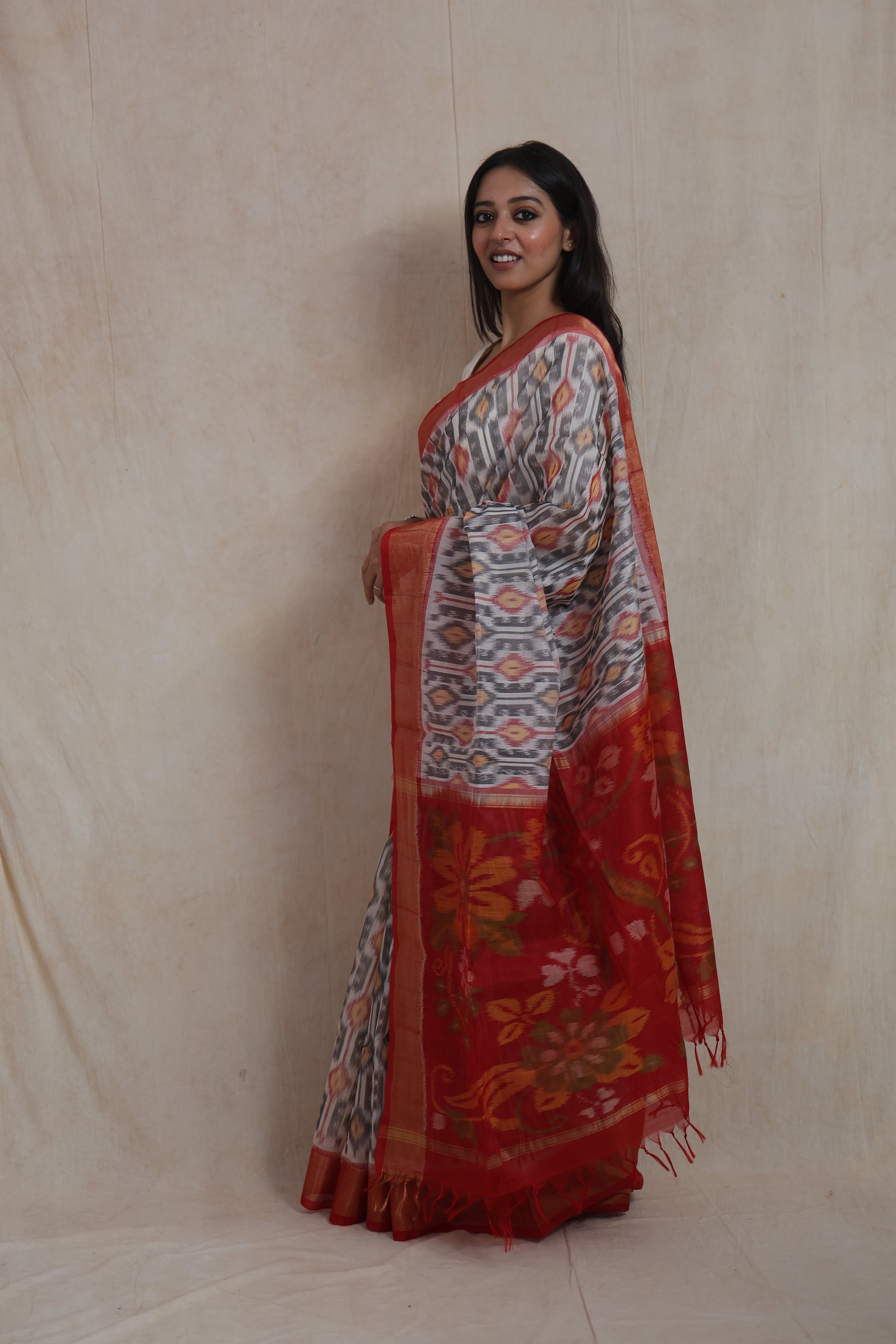 Side profile of handwoven ivory grey Pochampally SICO saree with red floral pallu
